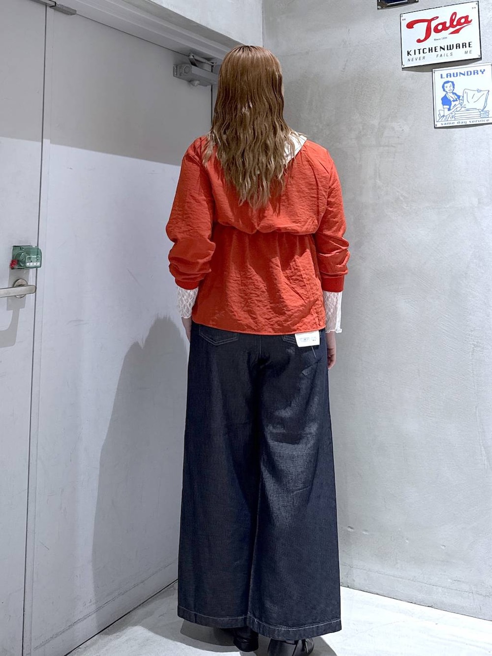 オレンジ系のシャツ/ブラウス、ホワイト系のTシャツ/カットソー、ブラック系のパンプスを着用したレディースの秋コーディネートの4枚目の写真
