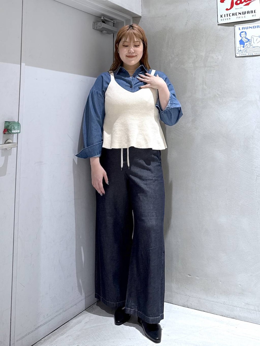 ホワイト系のベスト、ブラック系のパンプス、ブルー系のシャツ/ブラウスを着用したレディースの秋コーディネートの2枚目の写真