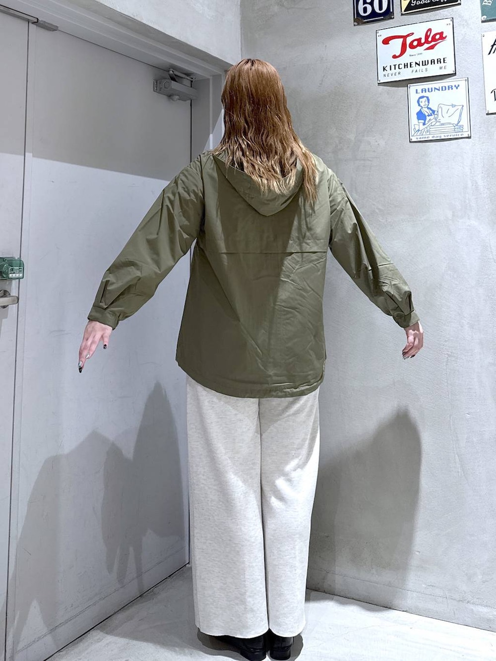 ブラック系のパンプス、グリーン系のマウンテンパーカー、ホワイト系のその他パンツを着用したレディースの秋コーディネートの4枚目の写真