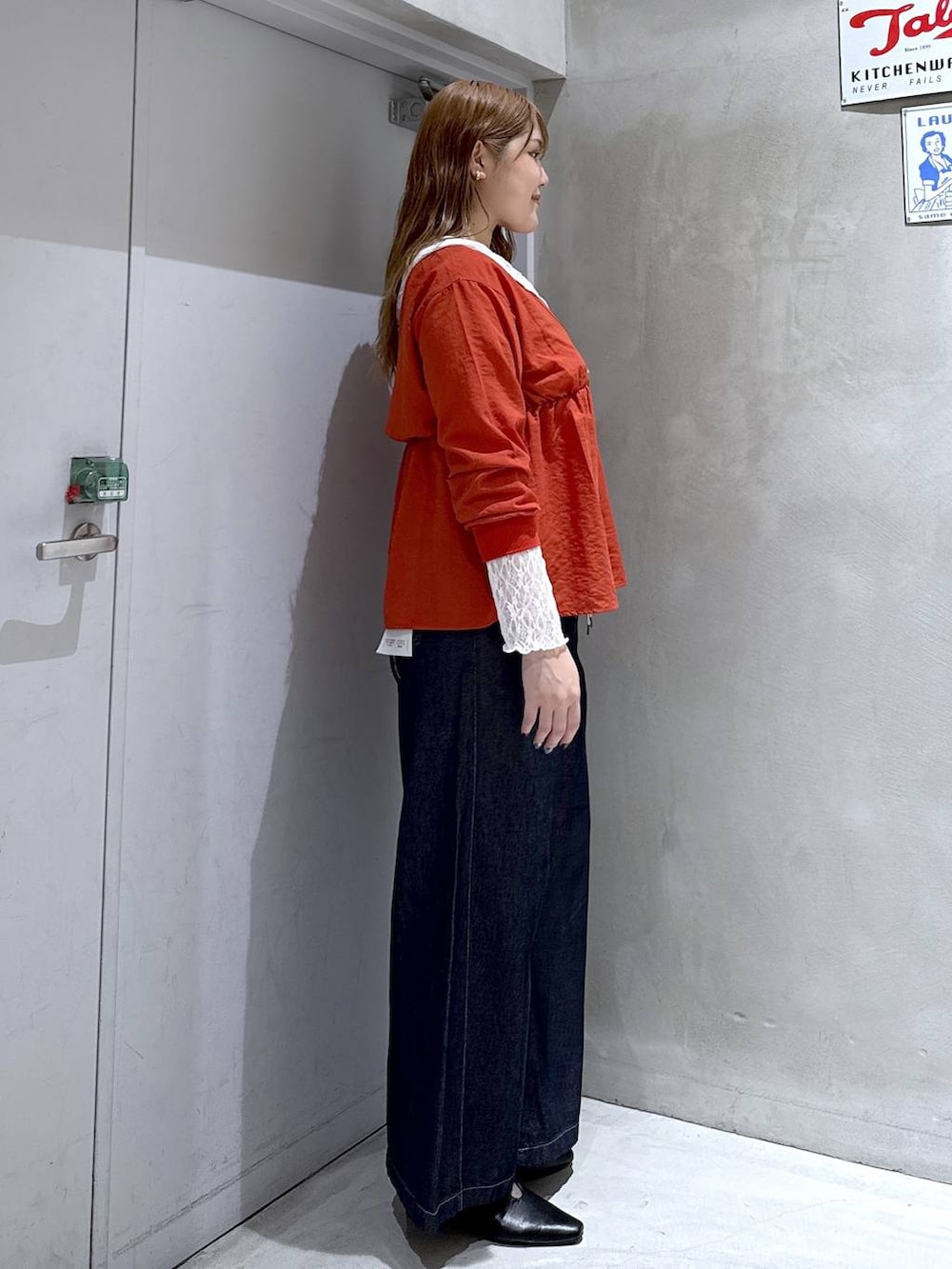 オレンジ系のシャツ/ブラウス、ホワイト系のTシャツ/カットソー、ブラック系のパンプスを着用したレディースの秋コーディネートの3枚目の写真