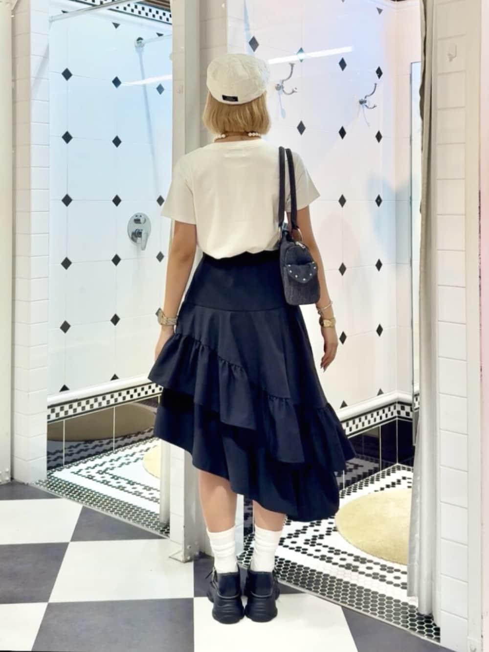 ブラック系のサンダル、ブラック系のスカート、ホワイト系のTシャツ/カットソーを着用したレディースの夏コーディネートの3枚目の写真
