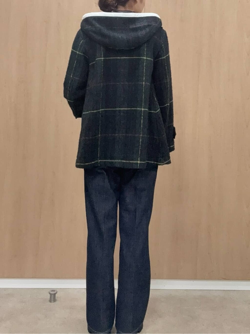 グリーン系のダッフルコート、ブルー系のデニムパンツ、ブラック系のカーディガン/ボレロを着用したレディースの秋コーディネートの3枚目の写真