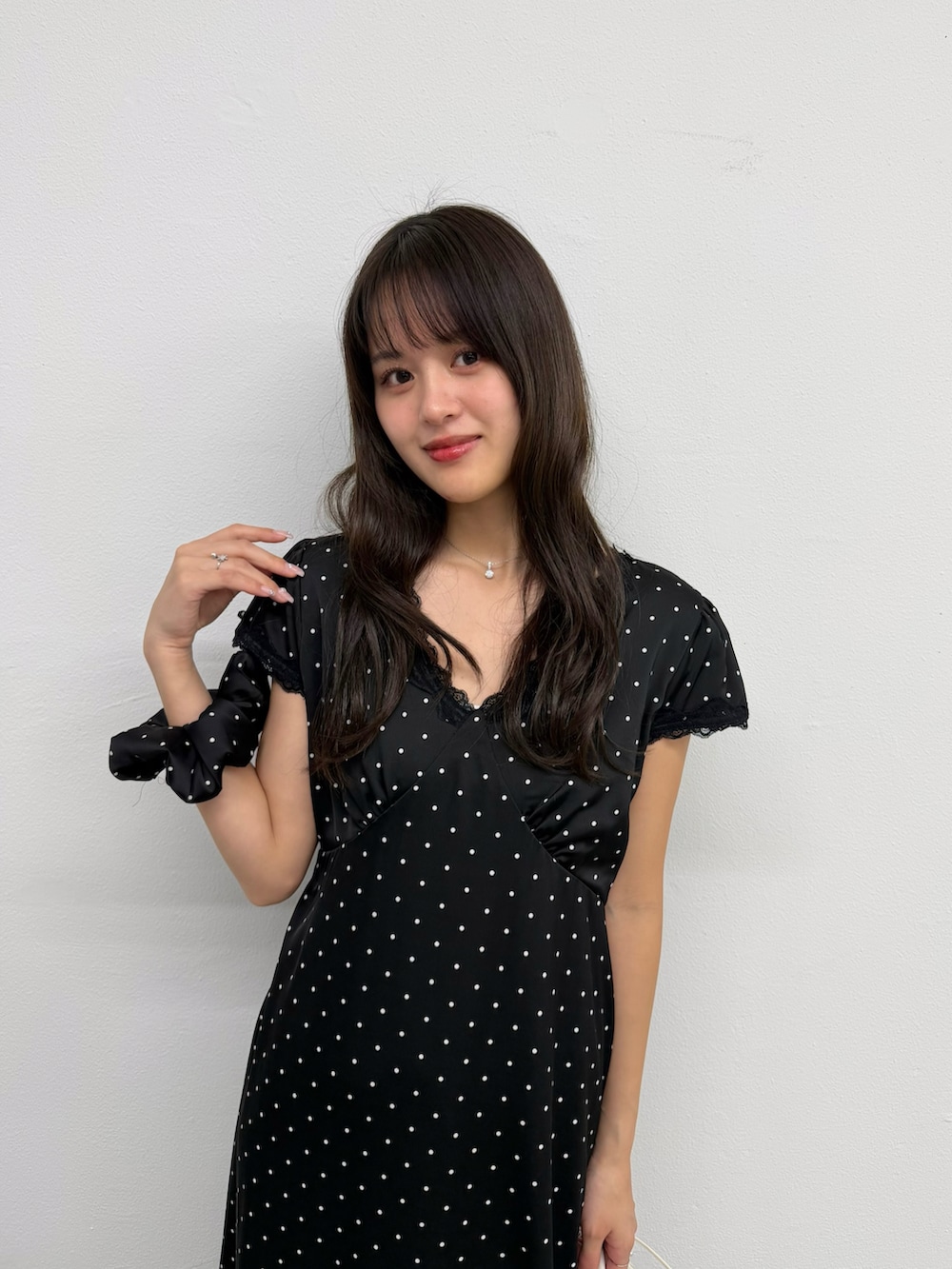 ブラック系のワンピース、ブラック系のパンプスを着用したレディースの春コーディネートの3枚目の写真