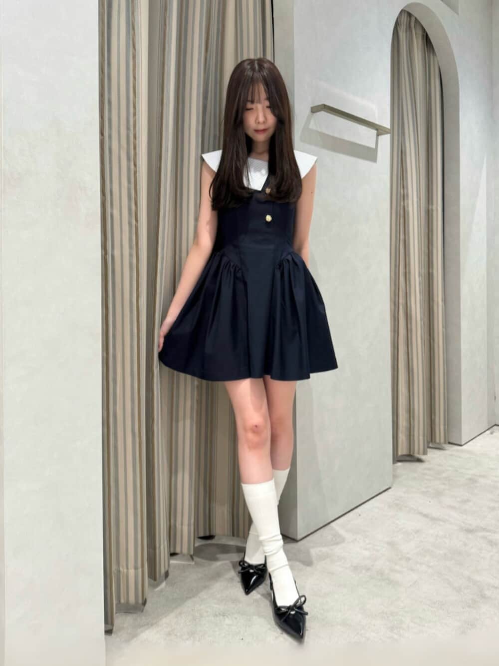 ブルー系のワンピース、ブラック系のパンプスを着用したレディースの夏コーディネートの2枚目の写真