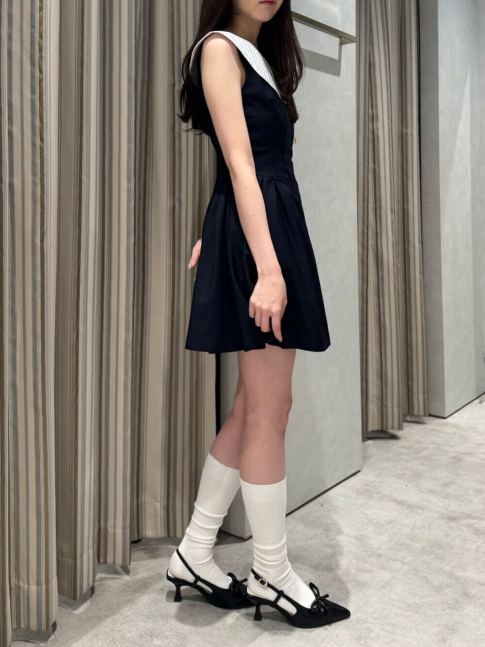 ブルー系のワンピース、ブラック系のパンプスを着用したレディースの夏コーディネートの3枚目の写真