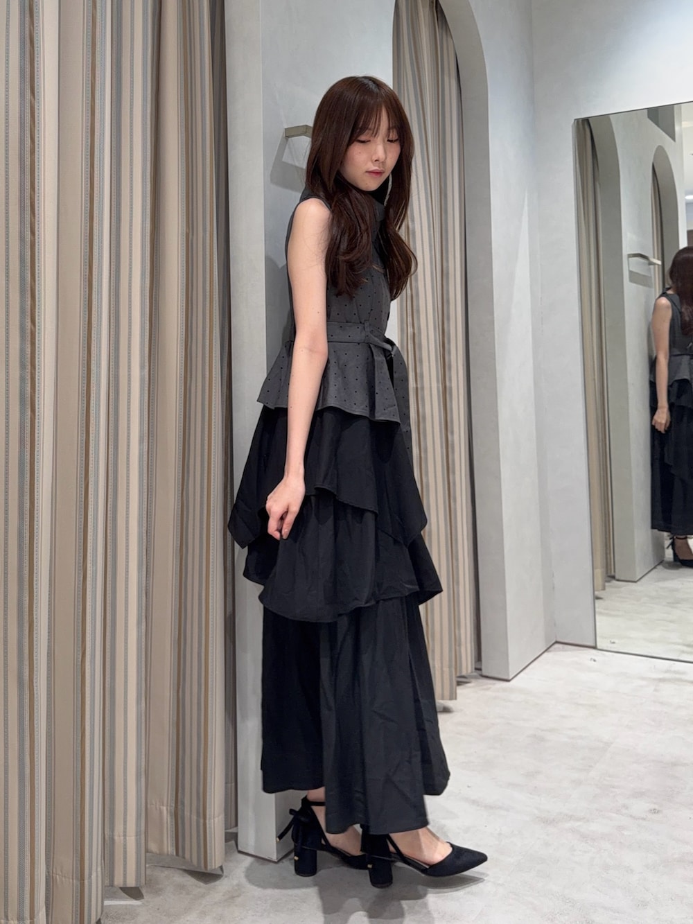 ブラック系のワンピース、ブラック系のパンプスを着用したレディースの夏コーディネートの2枚目の写真