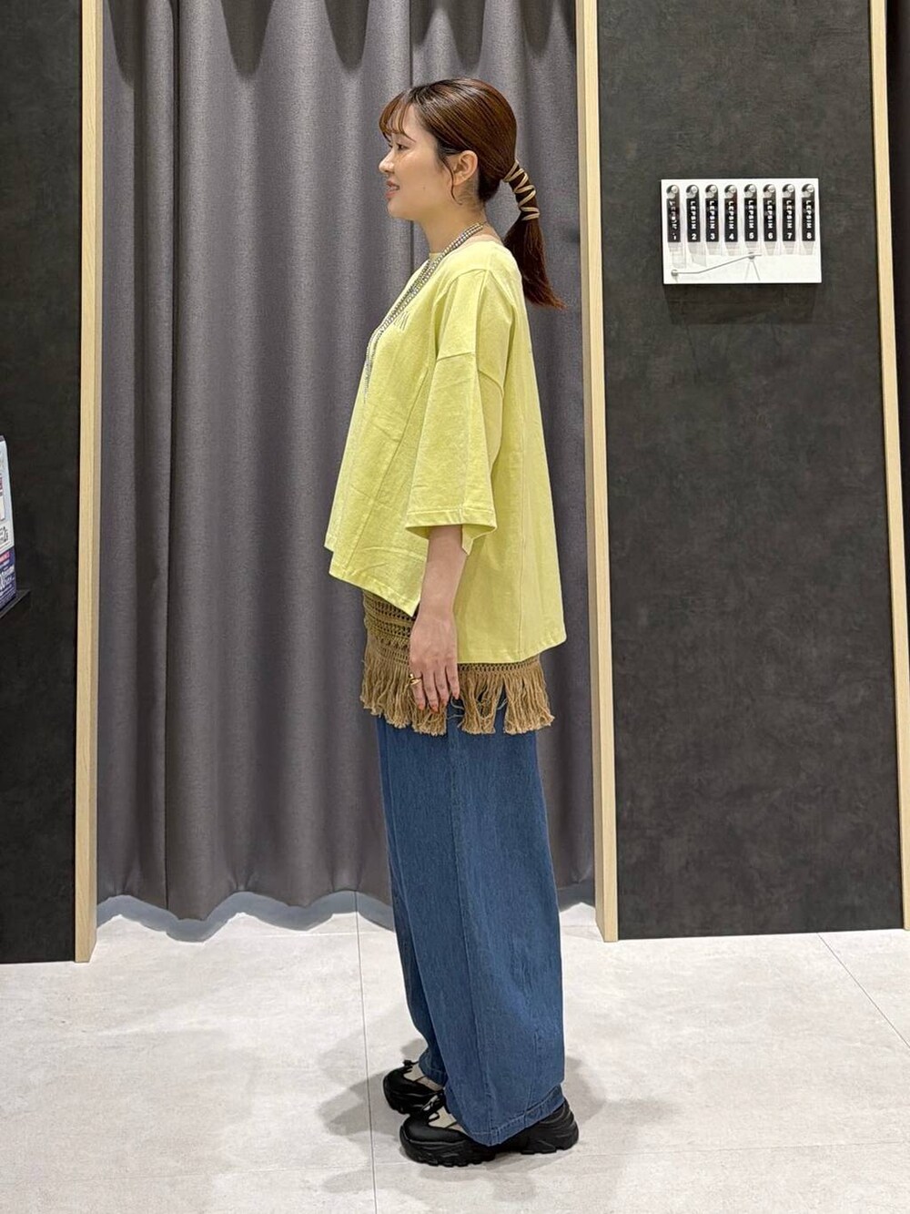 ホワイト系のサンダル、ベージュ系のスカート、ブルー系のデニムパンツを着用したレディースの春コーディネートの2枚目の写真