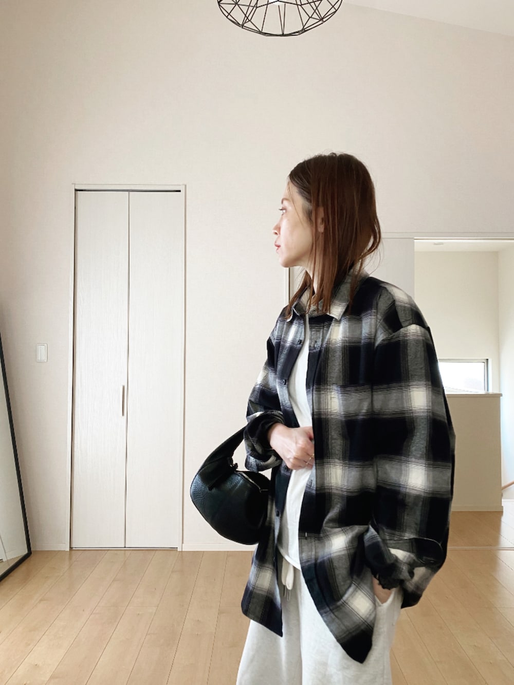 ブラック系のシャツ/ブラウス、ブラック系のスニーカー、ホワイト系のスウェットパンツを着用したレディースの秋コーディネートの2枚目の写真