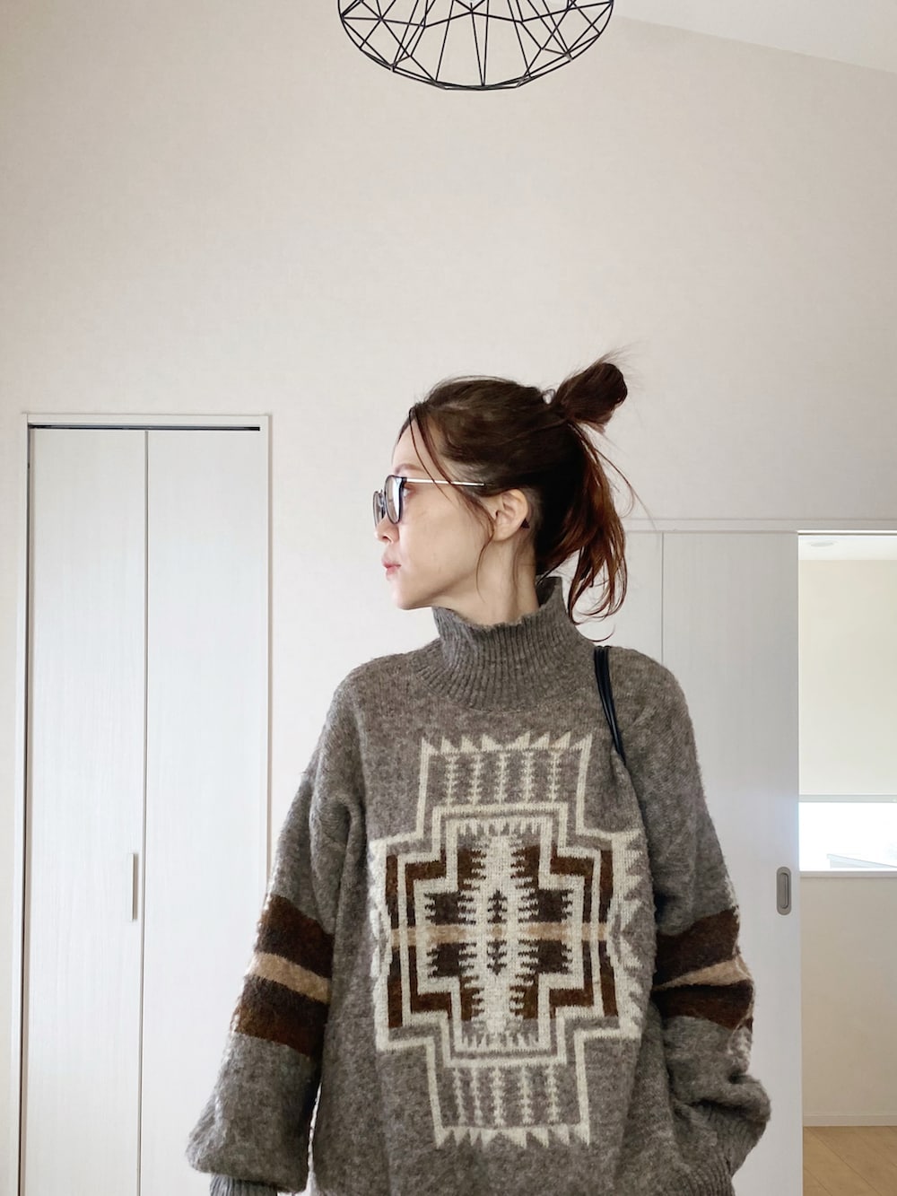 ブラック系のモカシン/デッキシューズ、ホワイト系のスウェットパンツ、ブラウン系のニット/セーターを着用したレディースの冬コーディネートの4枚目の写真