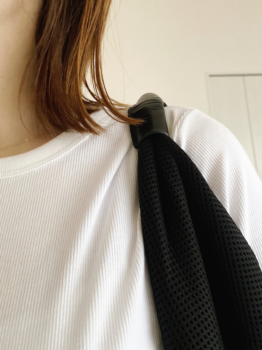 ホワイト系のTシャツ/カットソー、ブラック系のハンドバッグ、ブラック系のスラックスを着用したレディースの春コーディネートの3枚目の写真