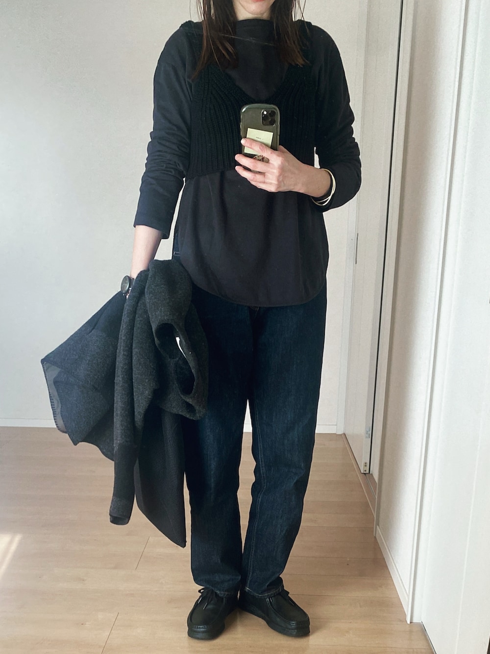 ブラック系のTシャツ/カットソー、ブラック系のハンドバッグ、ブルー系のデニムパンツを着用したレディースの冬コーディネートの3枚目の写真