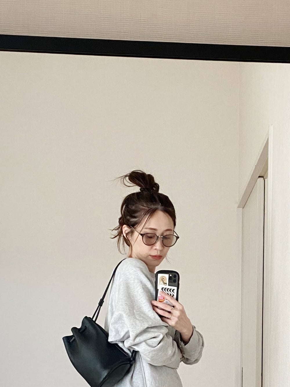 ブラック系のショルダーバッグ、ブラック系のモカシン/デッキシューズ、グレー系のスウェットを着用したレディースの冬コーディネートの2枚目の写真