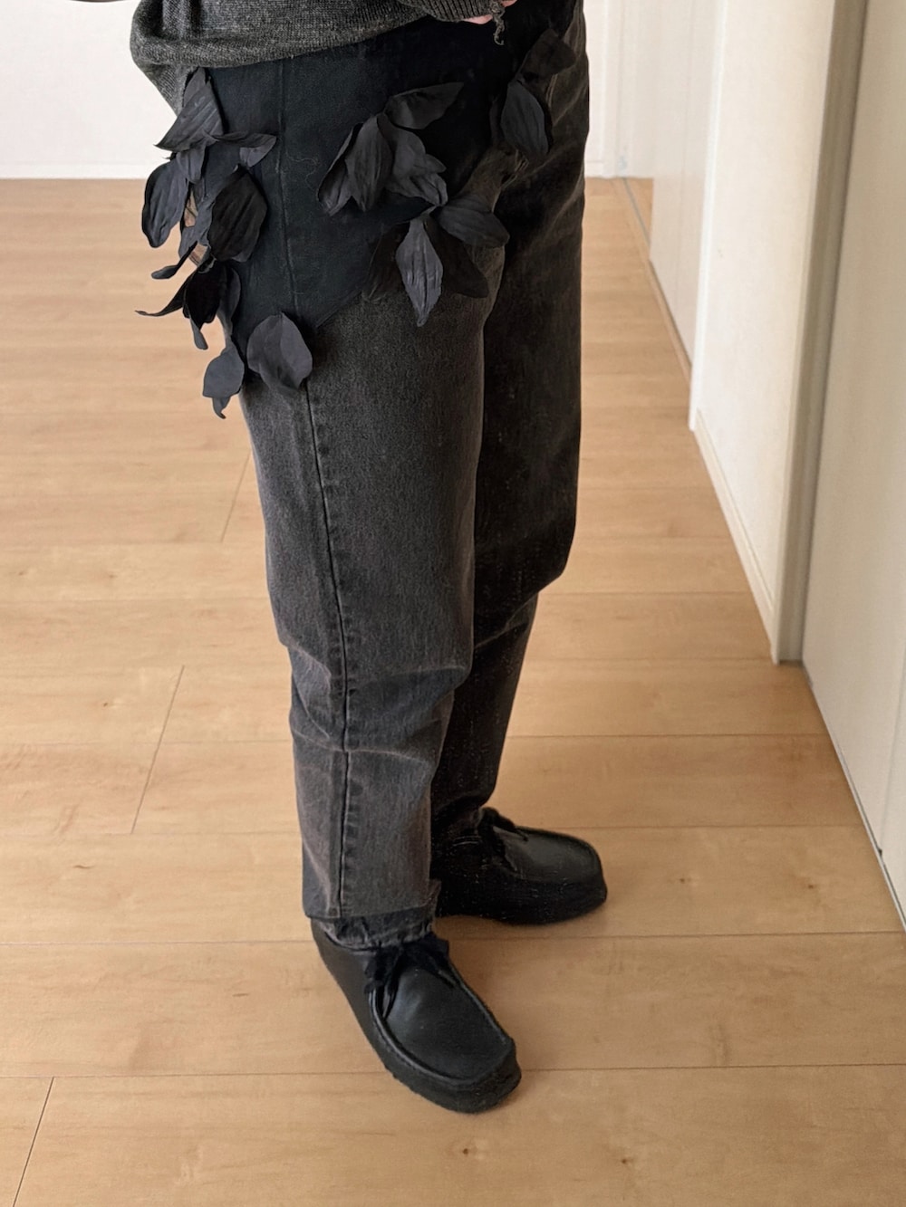 ブラック系のデニムパンツ、ブラック系のモカシン/デッキシューズ、グレー系のニット/セーターを着用したレディースの春コーディネートの4枚目の写真