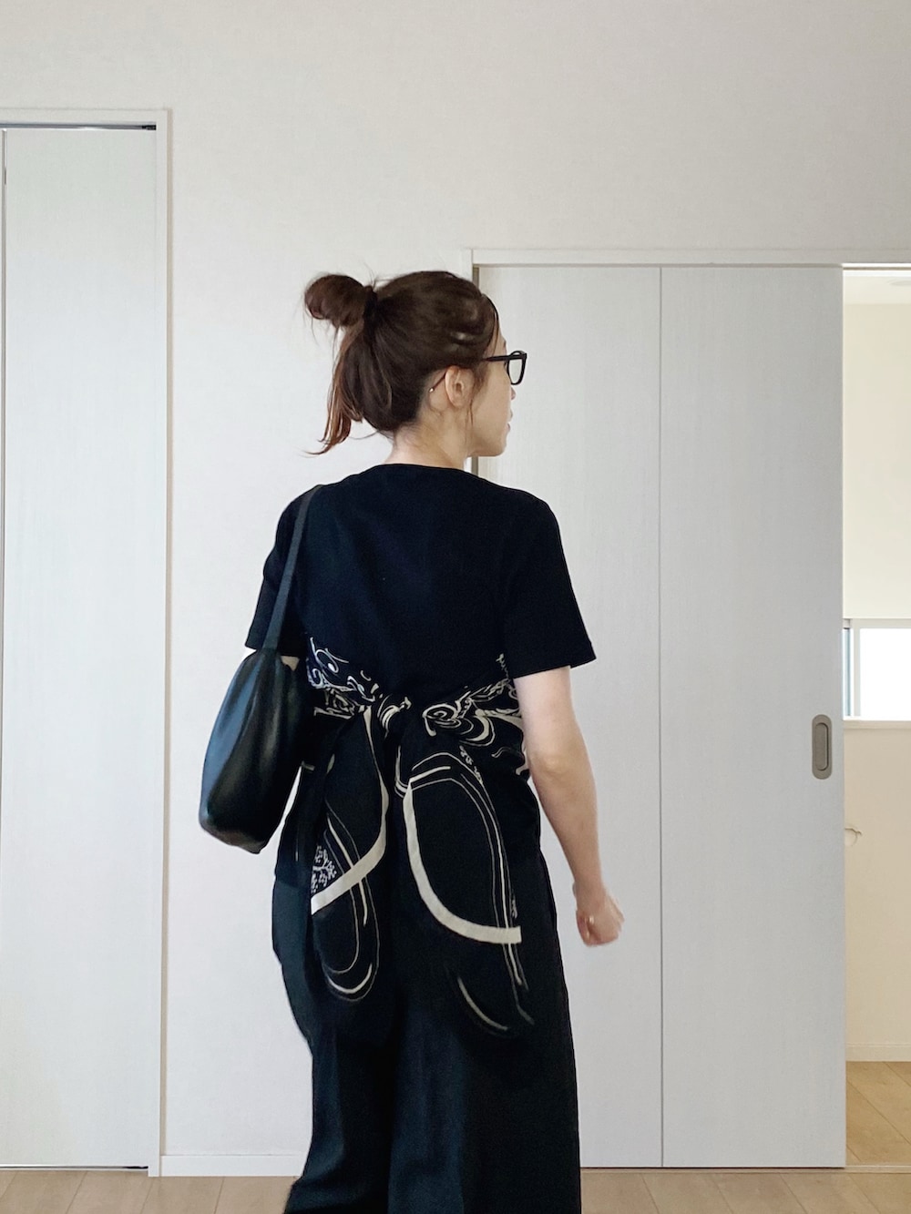 ブラック系のTシャツ/カットソー、ブラック系のスラックス、ブラック系のサンダルを着用したレディースの夏コーディネートの4枚目の写真