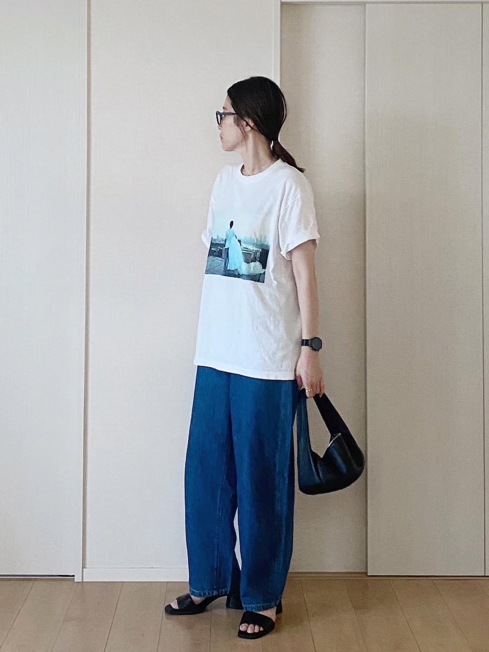 ホワイト系のTシャツ/カットソー、ブラック系のハンドバッグ、ブルー系のデニムパンツを着用したレディースの夏コーディネートの5枚目の写真