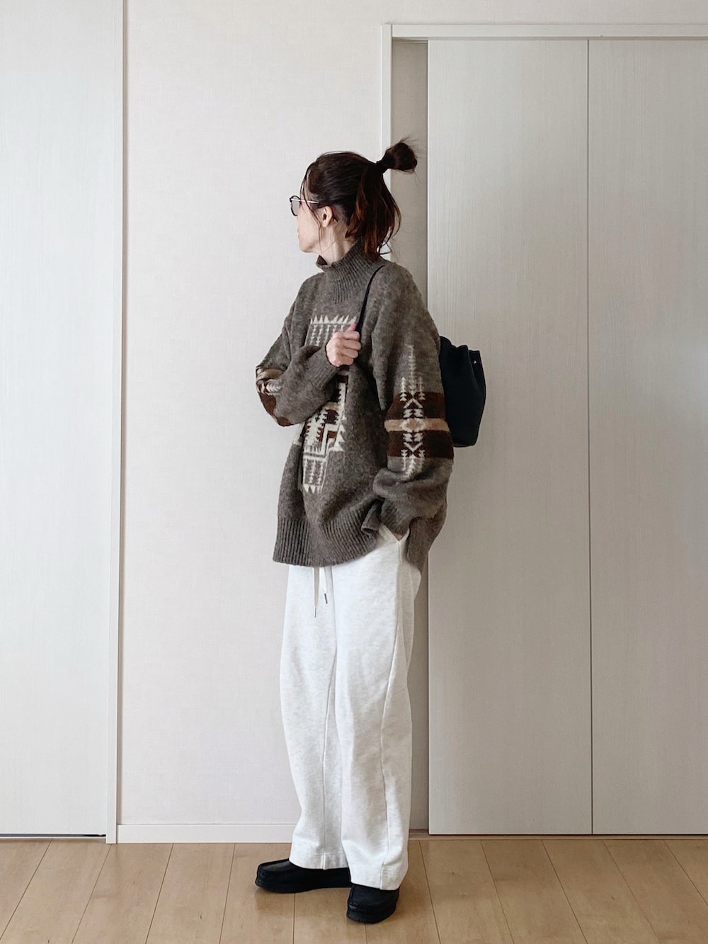 ブラック系のモカシン/デッキシューズ、ホワイト系のスウェットパンツ、ブラウン系のニット/セーターを着用したレディースの冬コーディネートの3枚目の写真