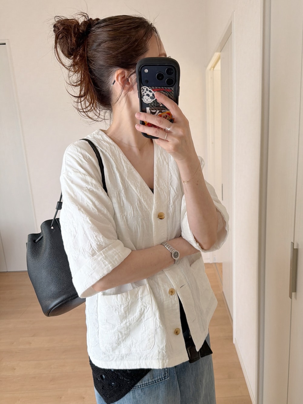 グレー系のタンクトップ、ブルー系のデニムパンツ、ブラック系のショルダーバッグを着用したレディースの夏コーディネートの2枚目の写真