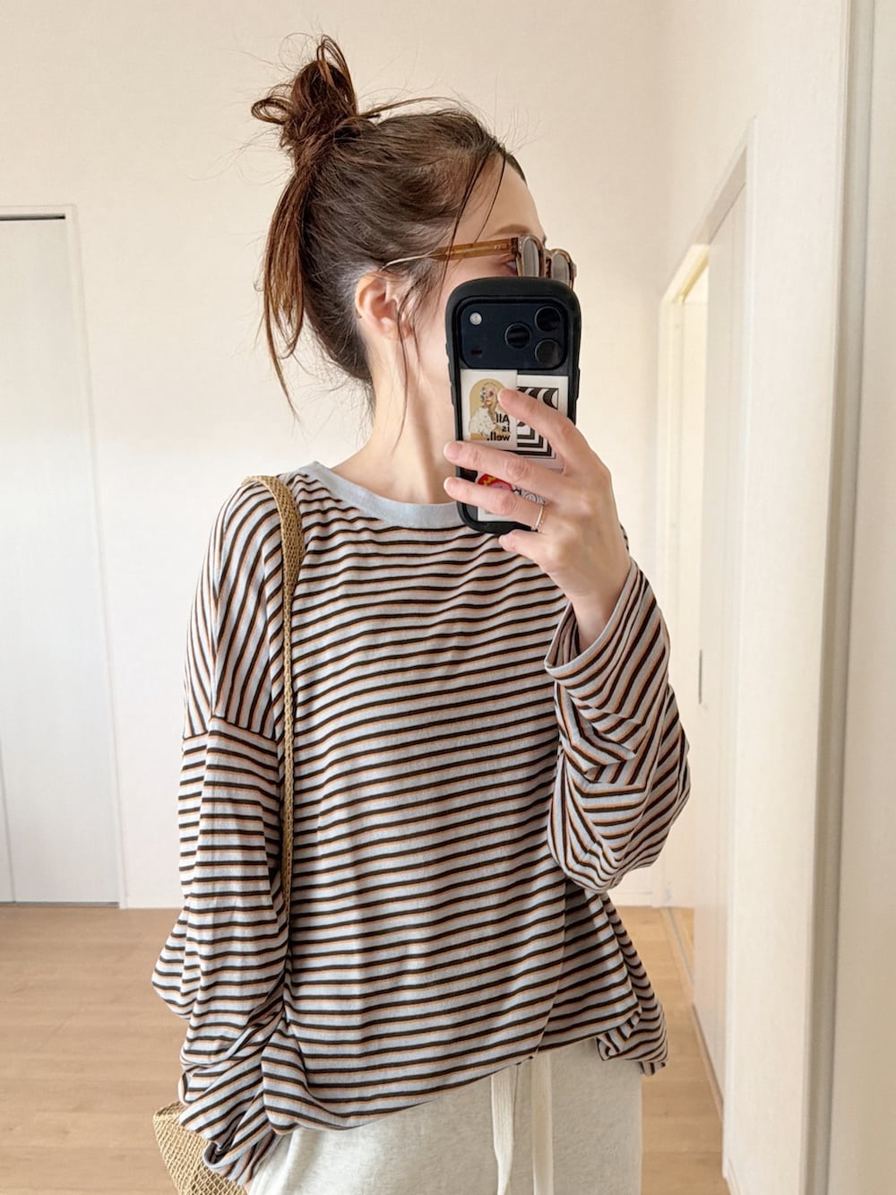 グレー系のニット/セーター、ホワイト系のスウェットパンツ、ベージュ系のショルダーバッグを着用したレディースの春コーディネートの3枚目の写真