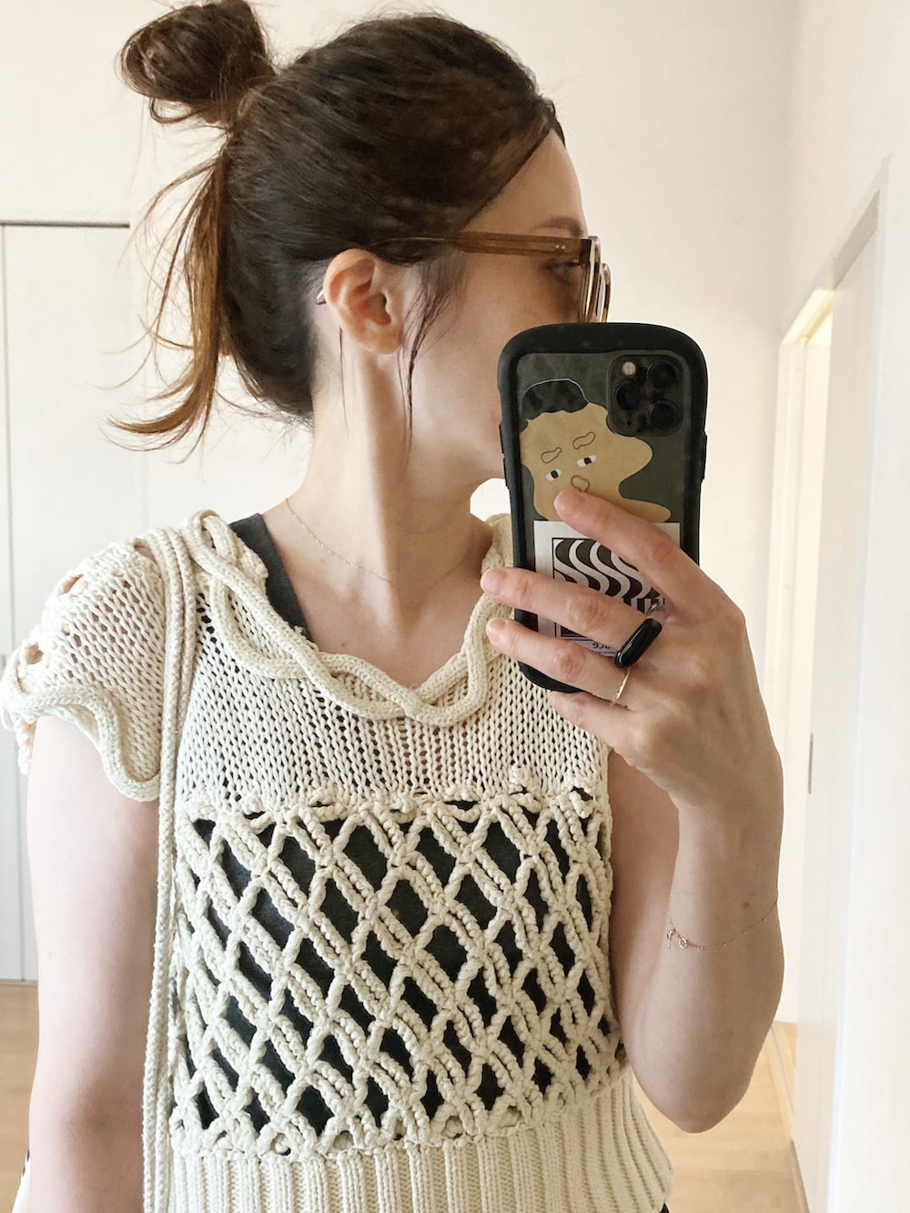 グレー系のタンクトップ、ブラック系のスラックス、ホワイト系のベストを着用したレディースの夏コーディネートの5枚目の写真