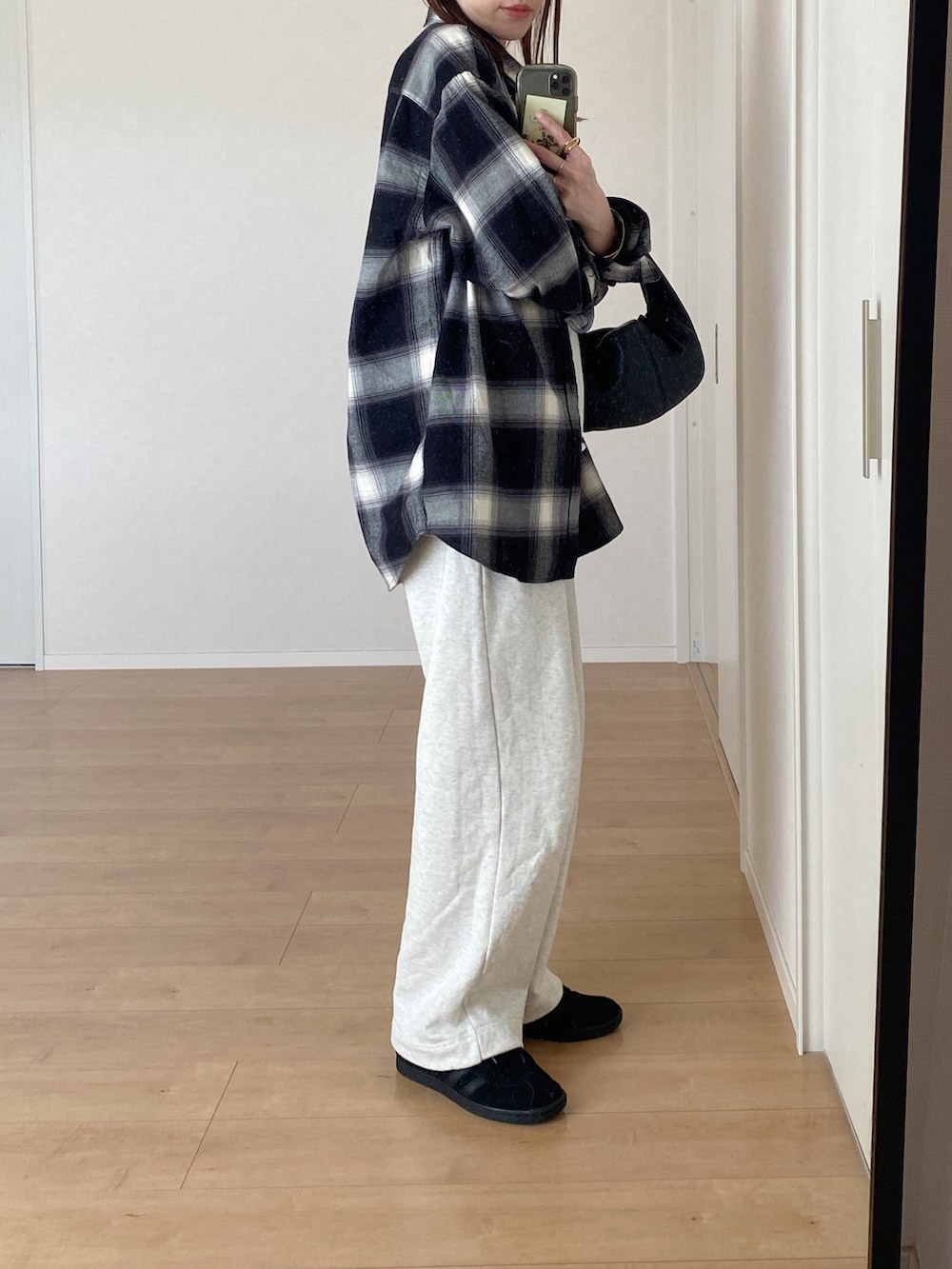 ブラック系のシャツ/ブラウス、ブラック系のスニーカー、ホワイト系のスウェットパンツを着用したレディースの秋コーディネートの3枚目の写真