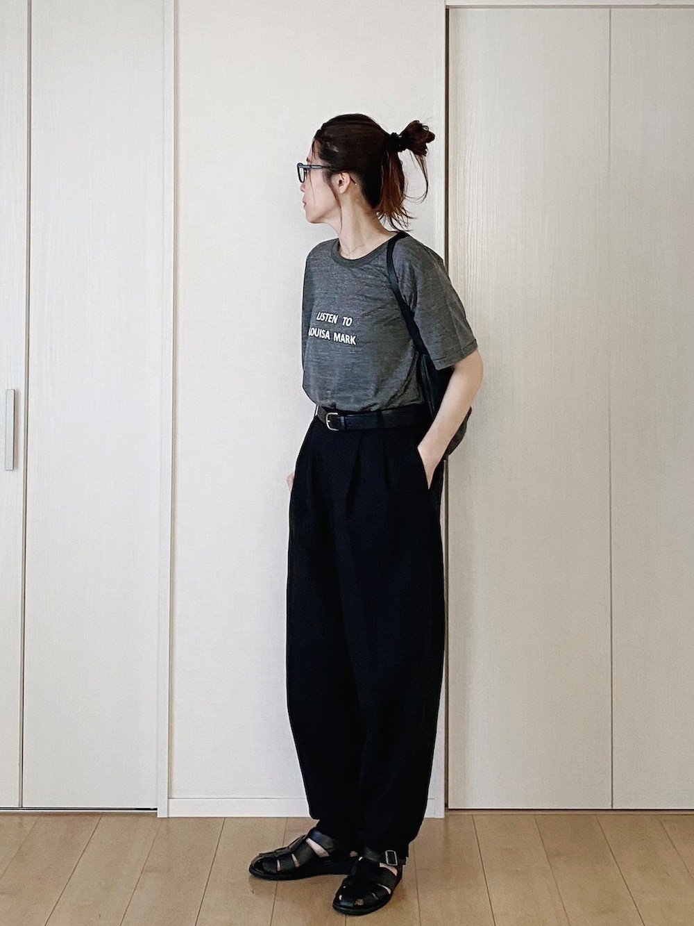 グレー系のTシャツ/カットソー、ブラック系のハンドバッグ、ブラック系のパンツを着用したレディースの夏コーディネートの2枚目の写真