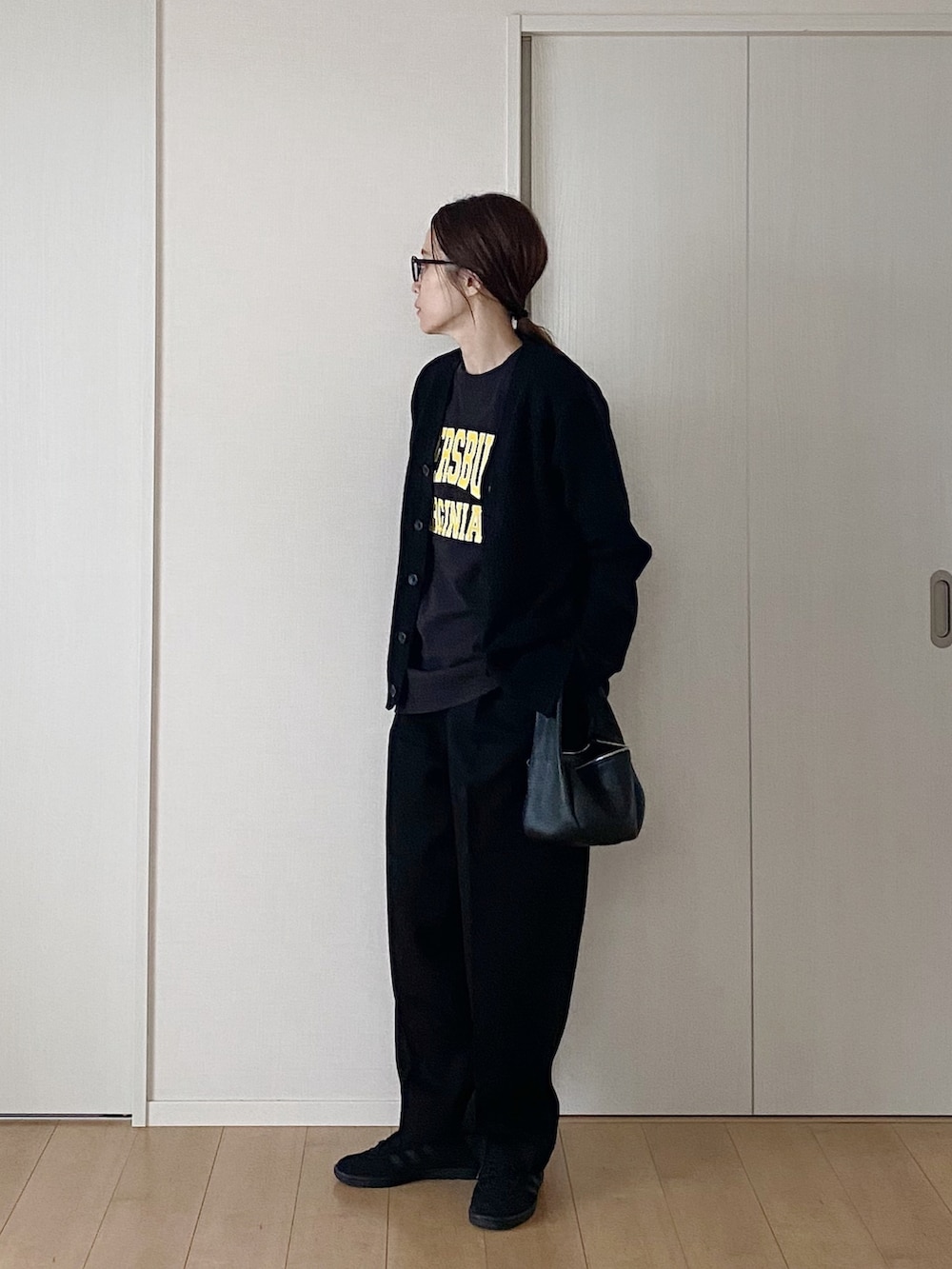 ブラック系のカーディガン/ボレロ、ブラック系のTシャツ/カットソー、ブラック系のハンドバッグを着用したレディースの冬コーディネートの2枚目の写真