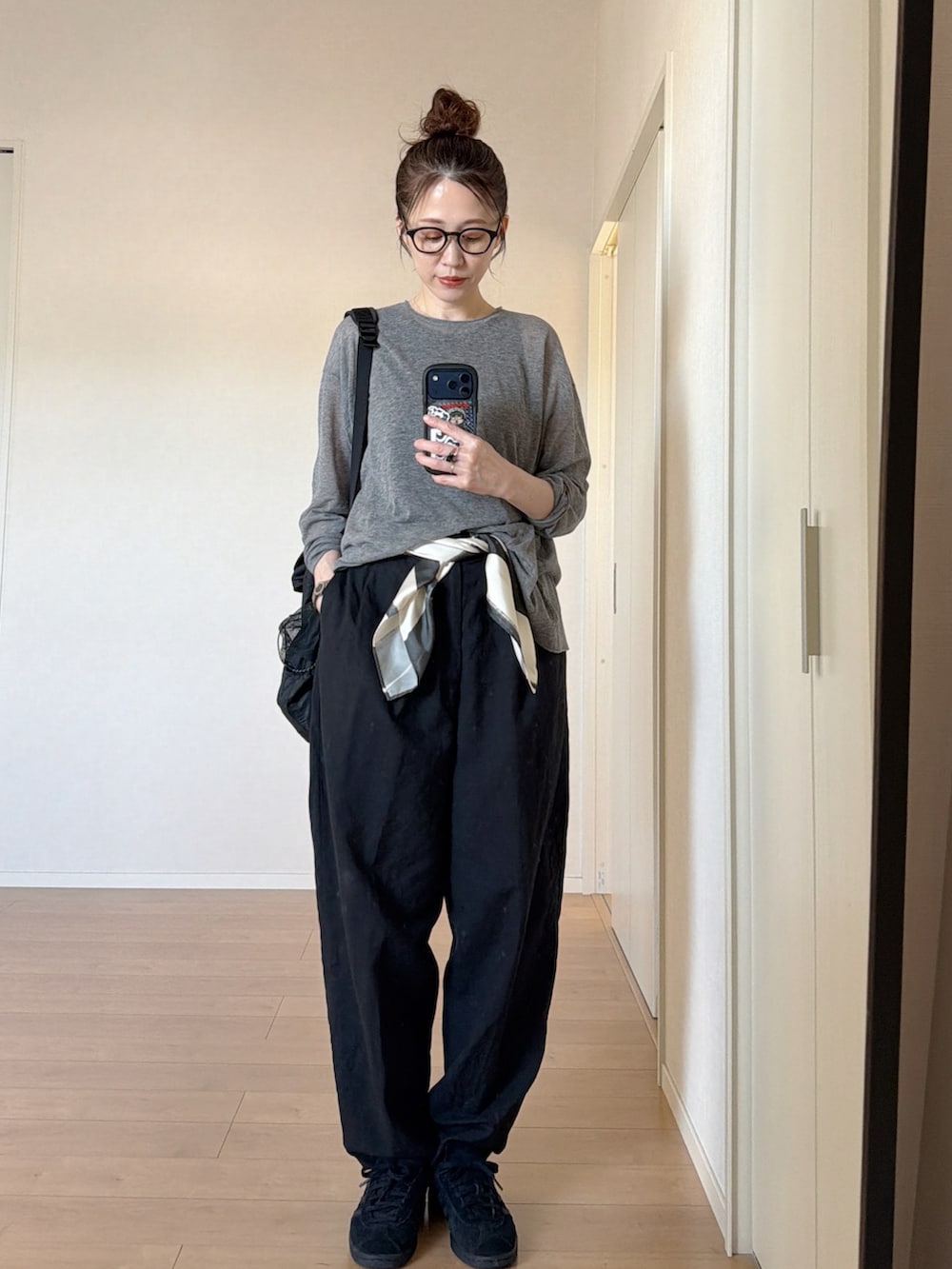 ブラック系のスニーカー、ブラック系のバックパック/リュック、グレー系のニット/セーターを着用したレディースの夏コーディネートの3枚目の写真