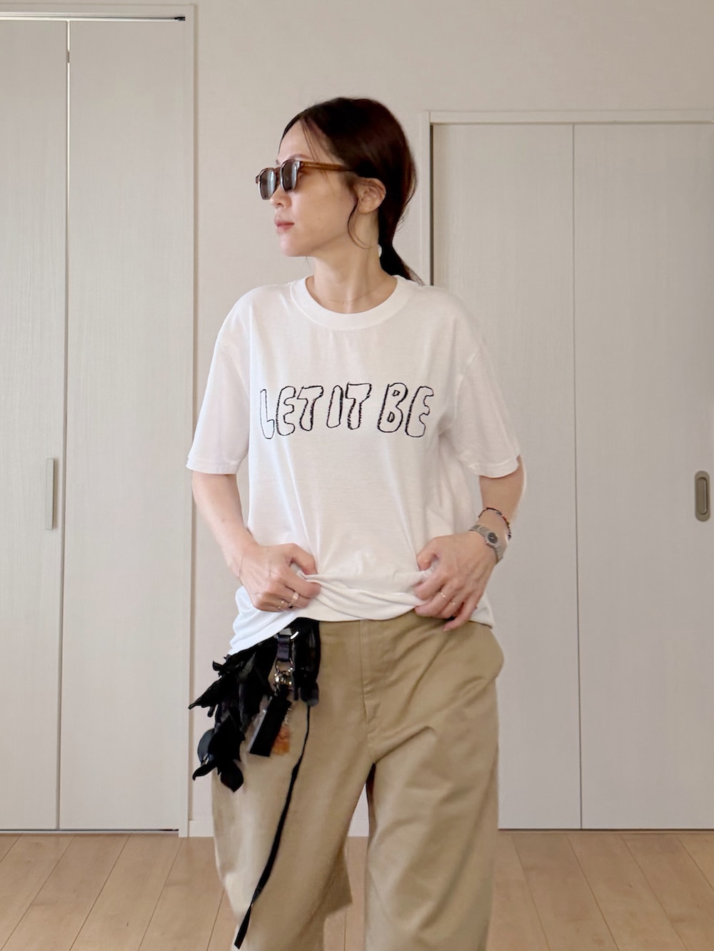 ホワイト系のTシャツ/カットソー、ブラック系のトートバッグ、その他のチノパンツを着用したレディースの秋コーディネートの3枚目の写真
