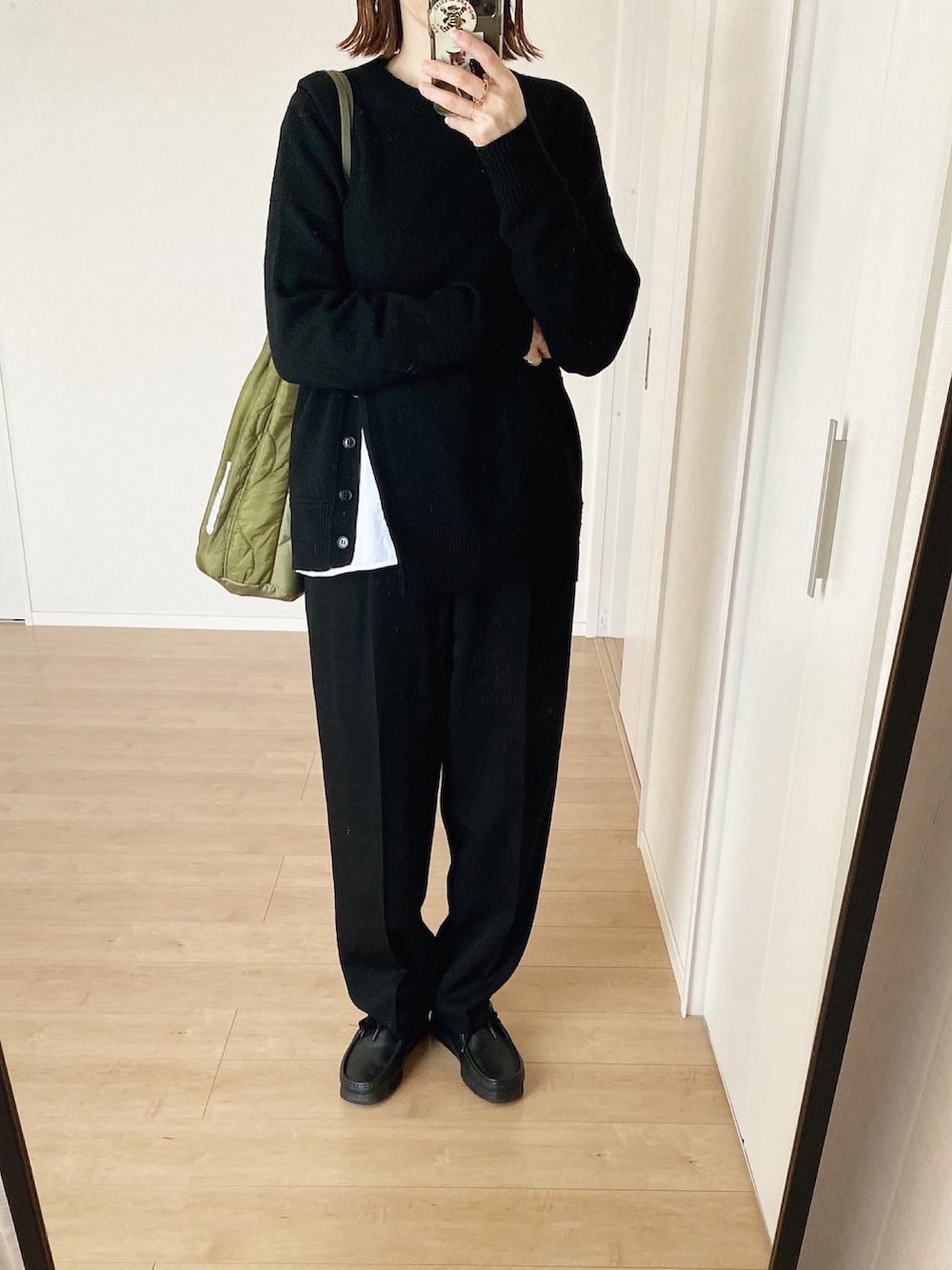 グリーン系のショルダーバッグ、ブラック系のその他パンツ、ブラック系のニット/セーターを着用したレディースの冬コーディネートの2枚目の写真