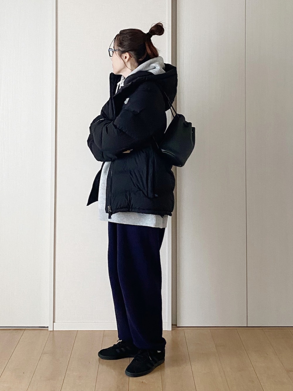 ブラック系のショルダーバッグ、ブラック系のスニーカー、グレー系のパーカーを着用したレディースの冬コーディネートの2枚目の写真