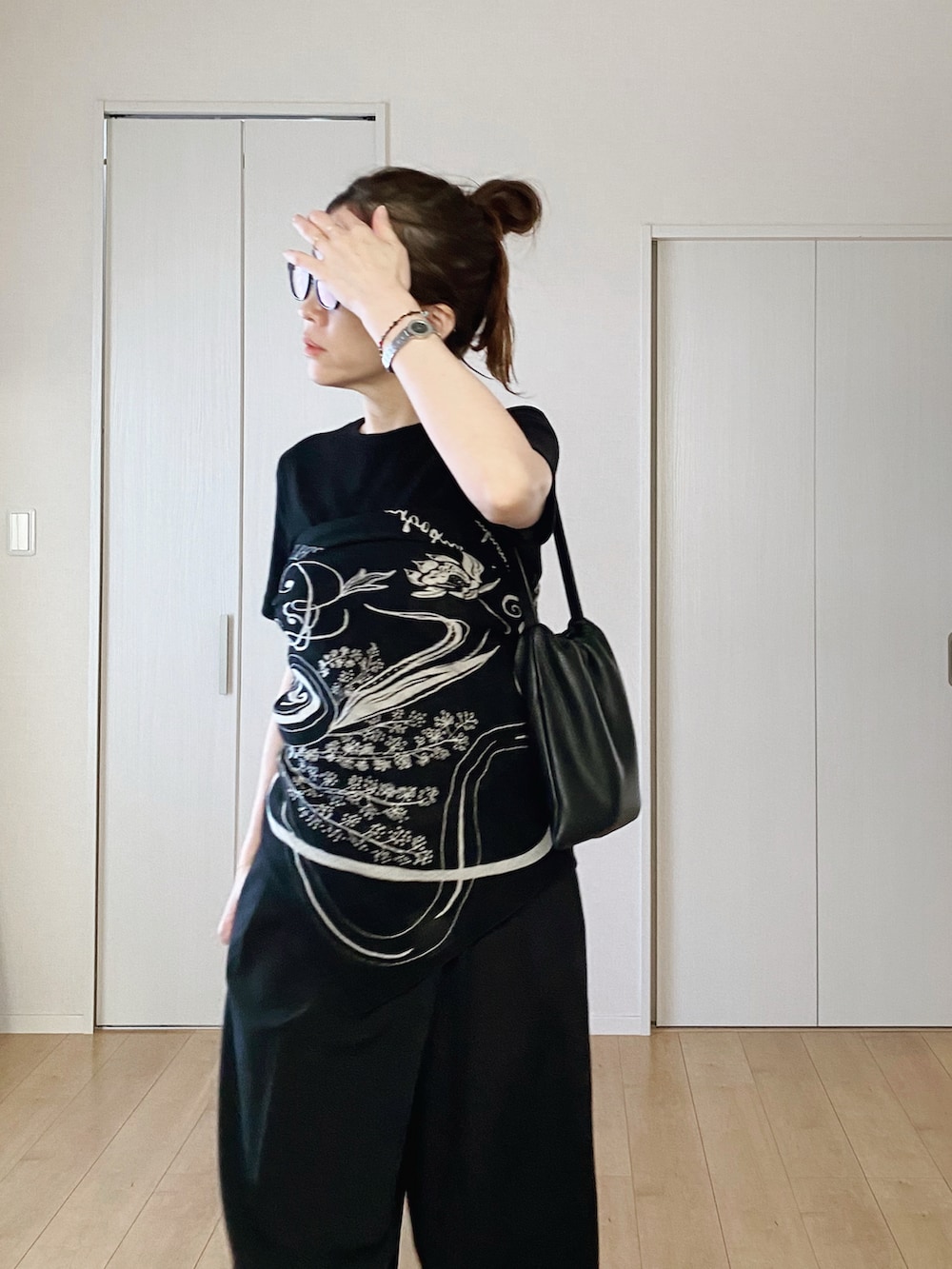 ブラック系のTシャツ/カットソー、ブラック系のスラックス、ブラック系のサンダルを着用したレディースの夏コーディネートの3枚目の写真