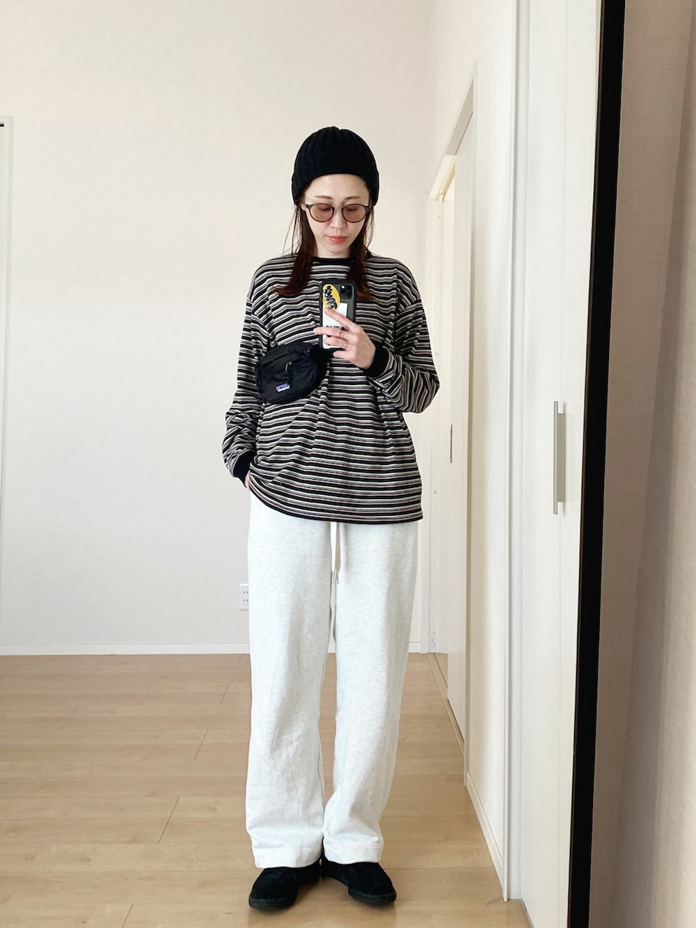 ブラック系のボディバッグ/ウエストポーチ、ホワイト系のスウェットパンツ、ブラック系のスニーカーを着用したレディースの春コーディネートの3枚目の写真