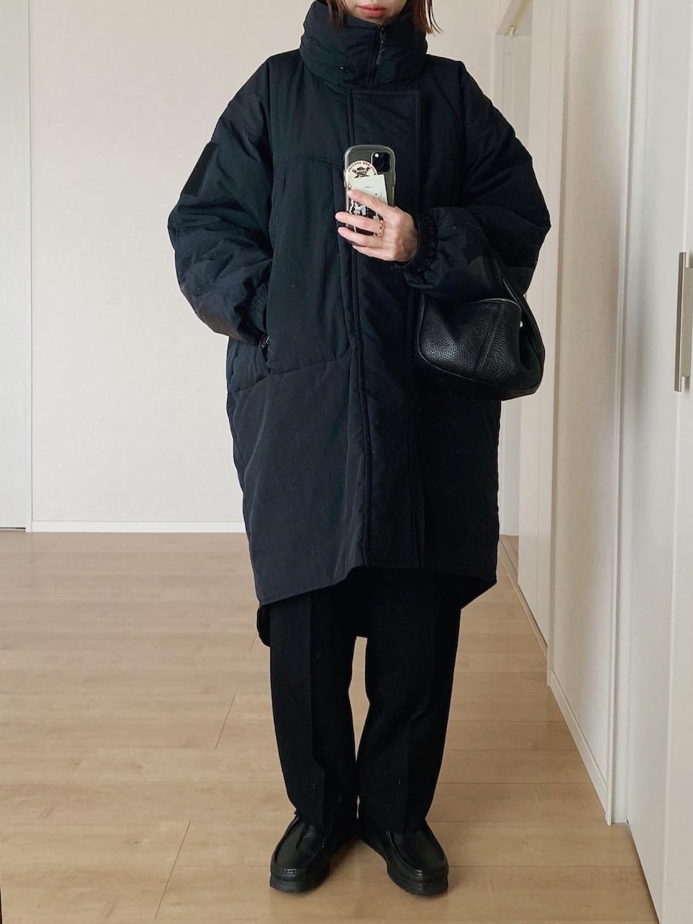 ブラック系のハンドバッグ、ブラック系のダウンジャケット/コート、ブラック系のその他パンツを着用したレディースの冬コーディネートの2枚目の写真