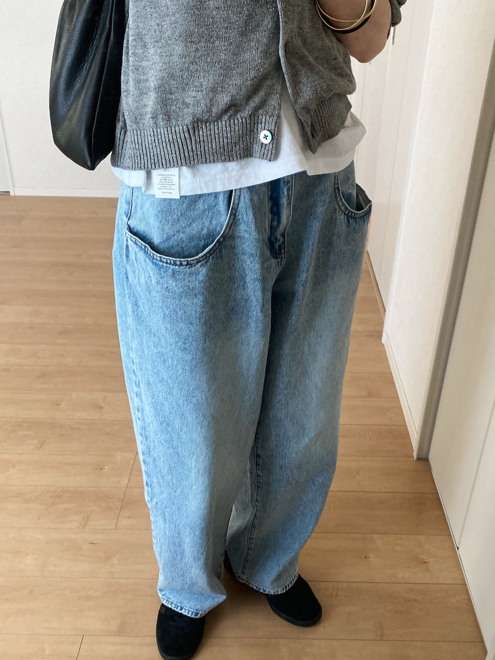 グレー系のカーディガン/ボレロ、ホワイト系のTシャツ/カットソー、ブルー系のデニムパンツを着用したレディースの春コーディネートの3枚目の写真