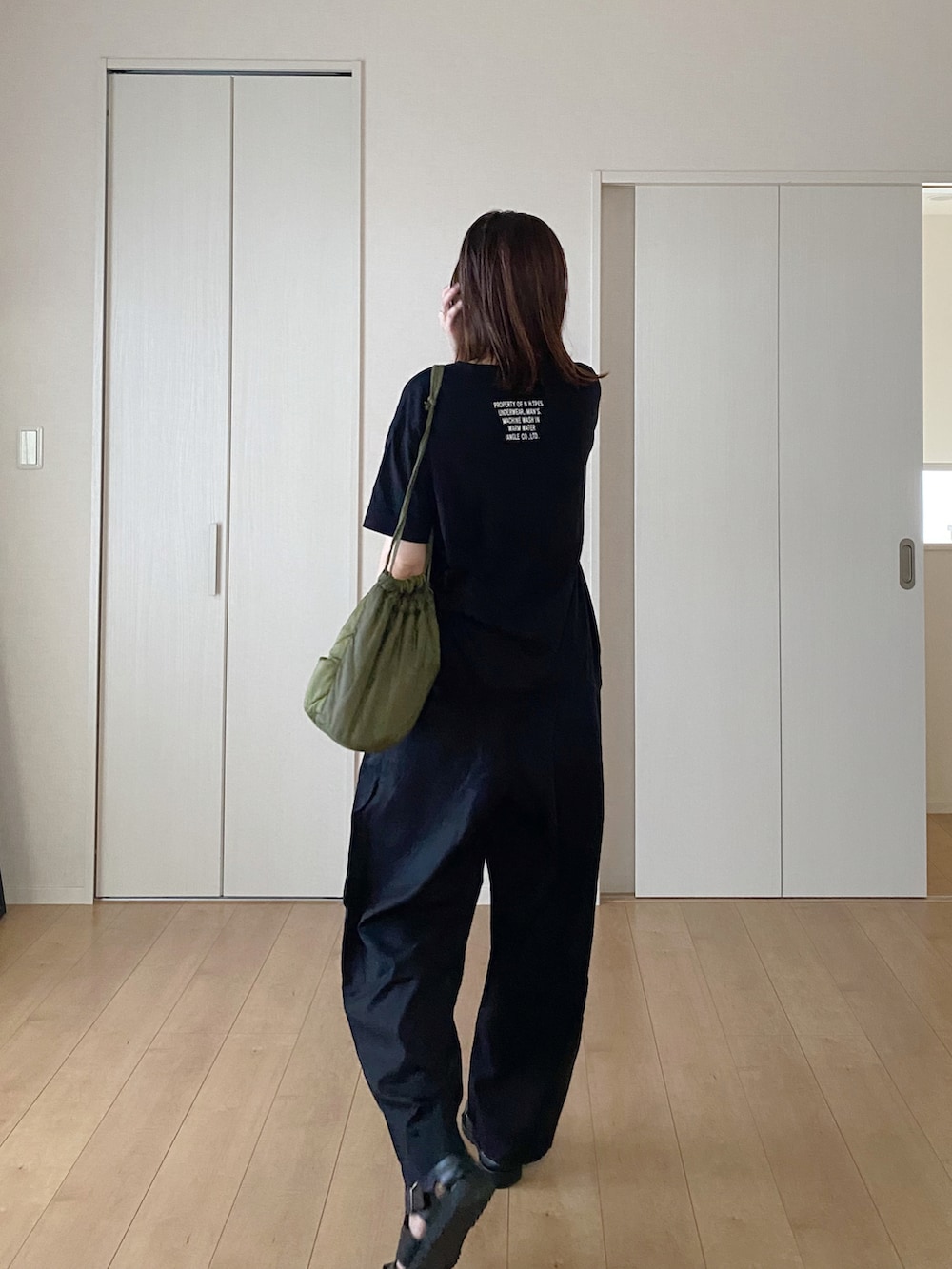 ブラック系のTシャツ/カットソー、ブラック系のショルダーバッグ、ブラウン系のその他パンツを着用したレディースの秋コーディネートの3枚目の写真