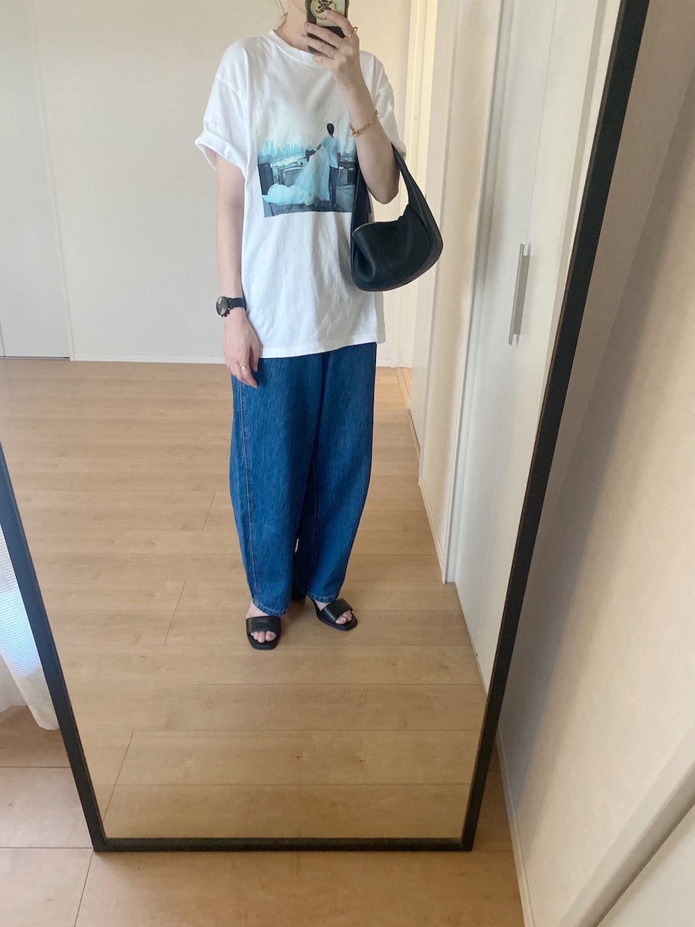 ホワイト系のTシャツ/カットソー、ブラック系のハンドバッグ、ブルー系のデニムパンツを着用したレディースの夏コーディネートの4枚目の写真