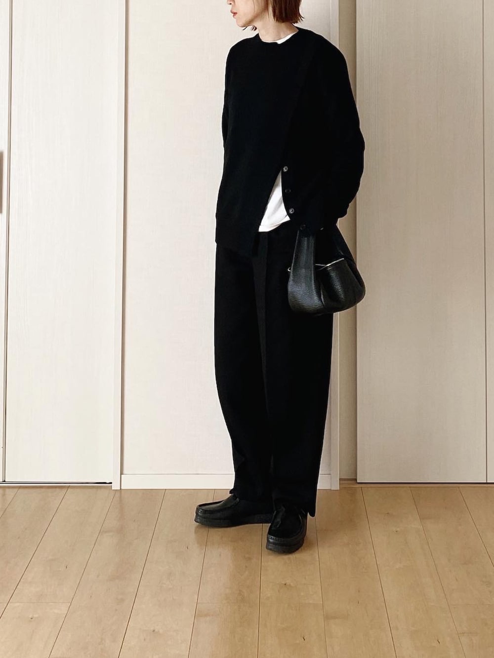 ブラック系のハンドバッグ、ブラック系のダウンジャケット/コート、ブラック系のその他パンツを着用したレディースの冬コーディネートの4枚目の写真