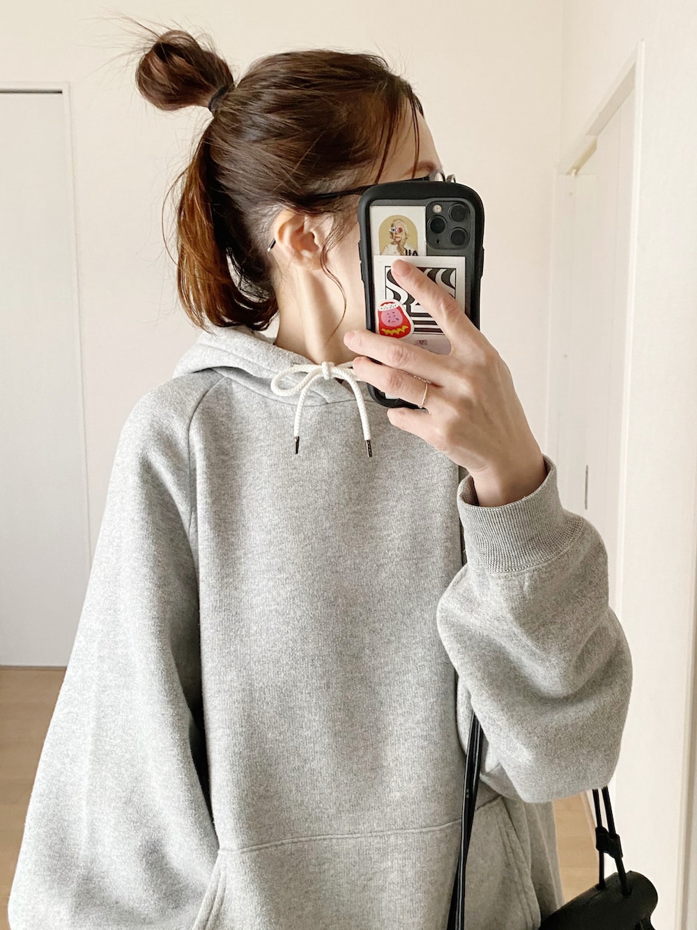 ブラック系のショルダーバッグ、ブラック系のスニーカー、グレー系のパーカーを着用したレディースの冬コーディネートの3枚目の写真