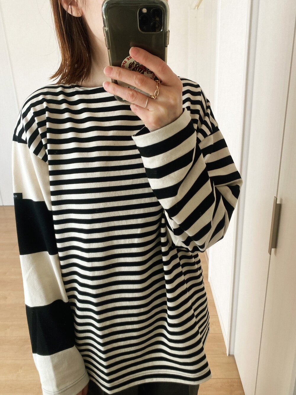 ブラック系のTシャツ/カットソー、グレー系のスラックス、ブラック系のハンドバッグを着用したレディースの春コーディネートの2枚目の写真