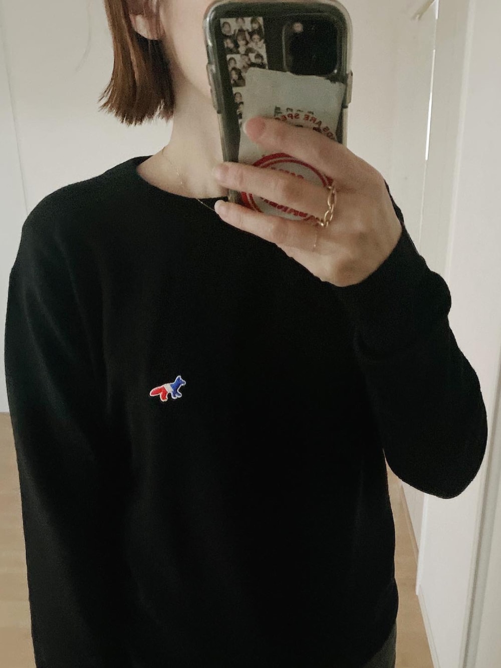 ブラック系のニット/セーター、ブラック系のデニムパンツ、ブラック系のハンドバッグを着用したレディースの冬コーディネートの3枚目の写真