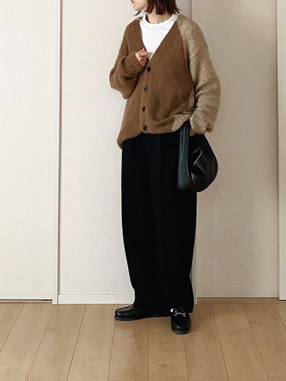 ベージュ系のニット/セーター、ブラック系のその他パンツ、ブラック系のハンドバッグを着用したレディースの冬コーディネートの3枚目の写真