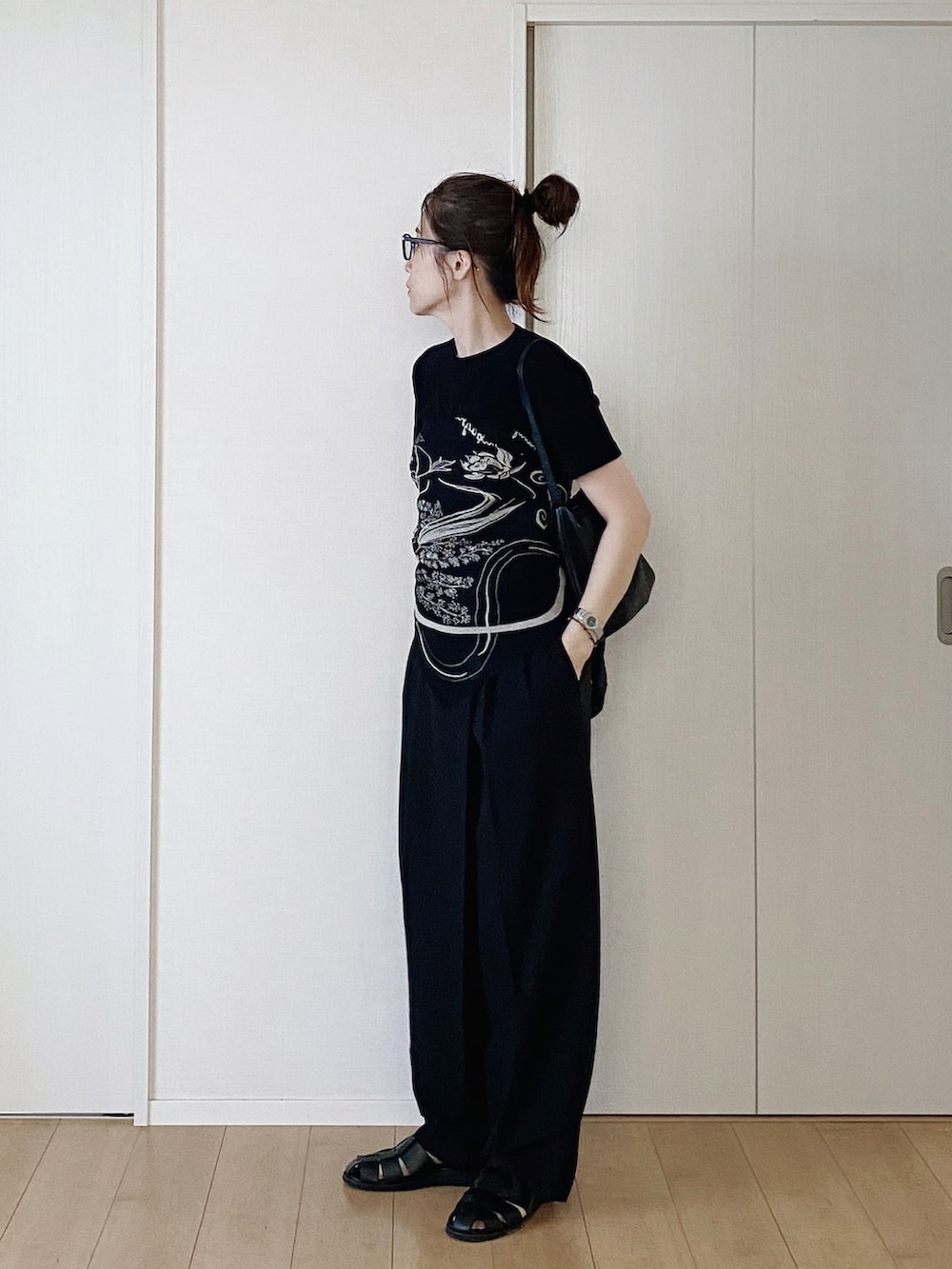 ブラック系のTシャツ/カットソー、ブラック系のスラックス、ブラック系のサンダルを着用したレディースの夏コーディネートの2枚目の写真