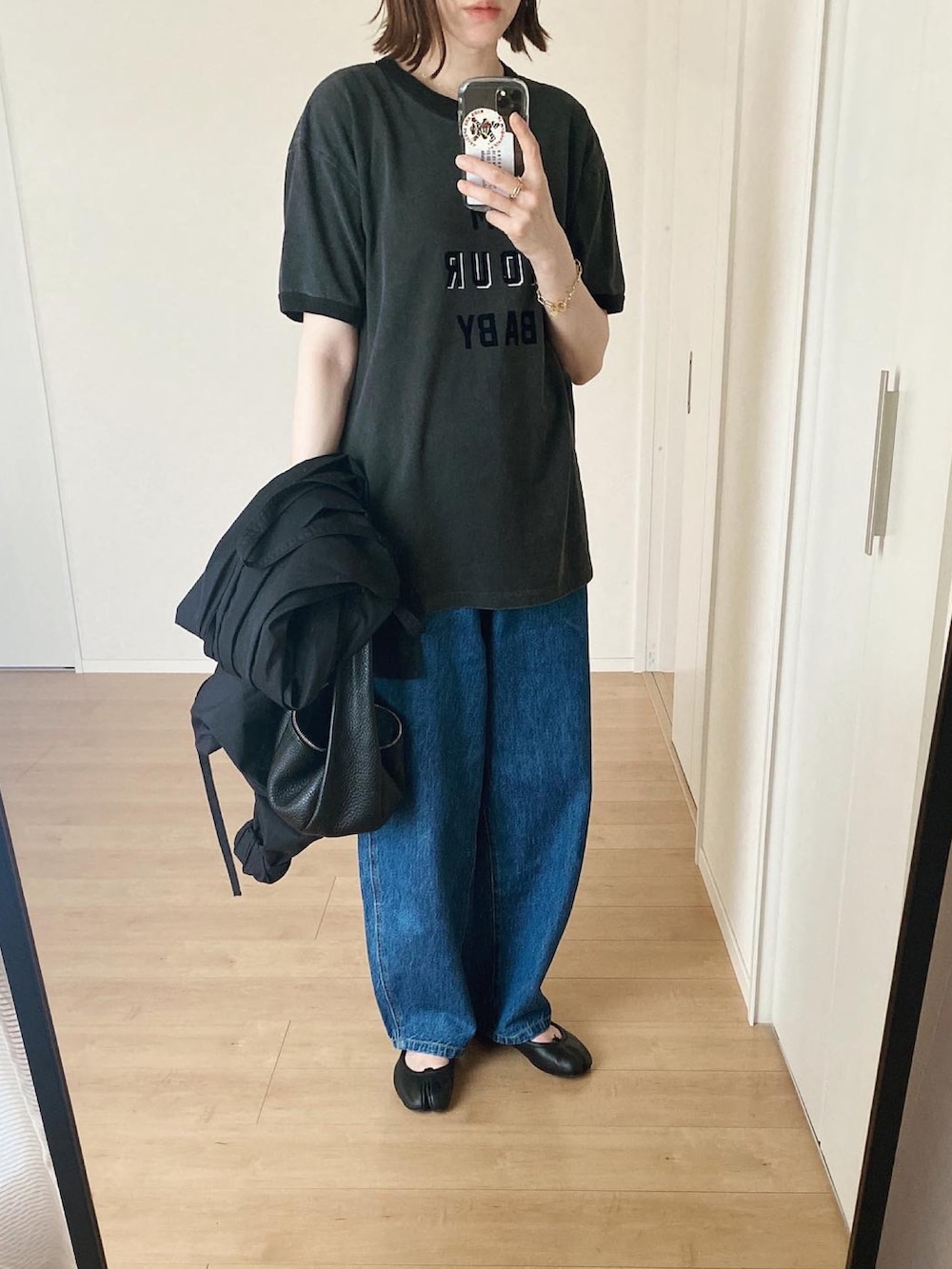 ブラック系のその他アウター、ブラック系のバレエシューズ、ブラック系のハンドバッグを着用したレディースの夏コーディネートの3枚目の写真