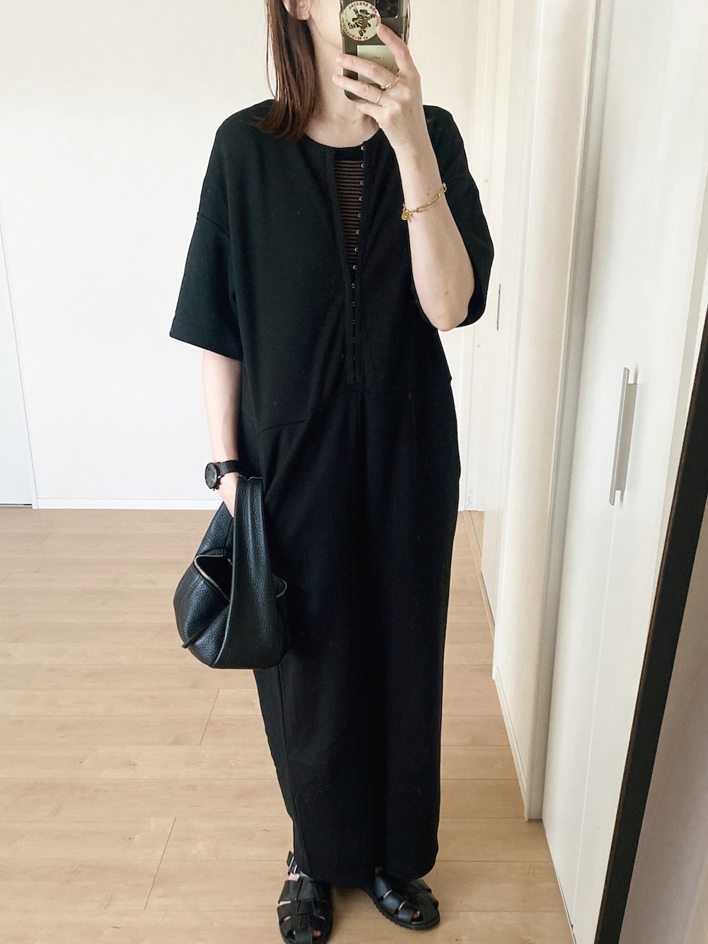 ブラック系のサロペット/オーバーオール、ブラック系のハンドバッグ、ブラック系のサンダルを着用したレディースの夏コーディネートの2枚目の写真