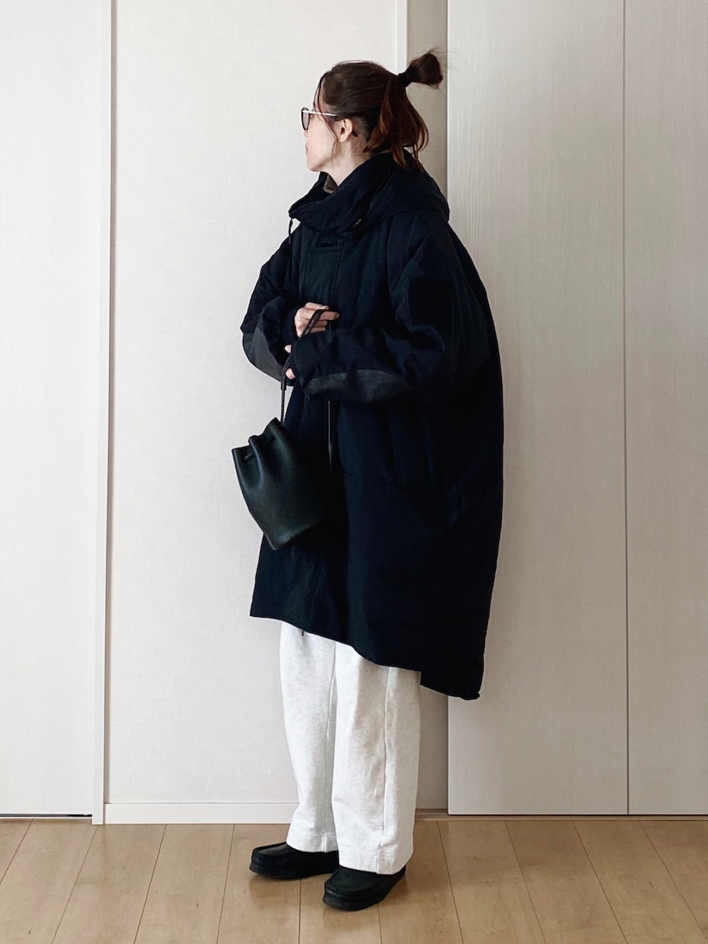 ブラック系のモカシン/デッキシューズ、ホワイト系のスウェットパンツ、ブラウン系のニット/セーターを着用したレディースの冬コーディネートの2枚目の写真