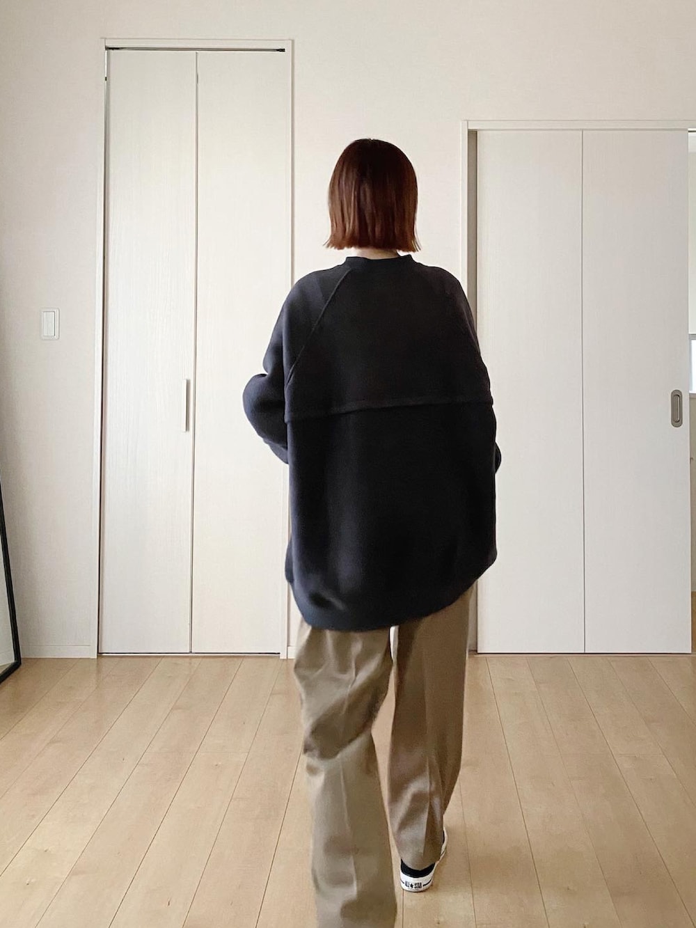 ブラック系のスウェット、ベージュ系のその他パンツ、ブラック系のスニーカーを着用したレディースの秋コーディネートの2枚目の写真