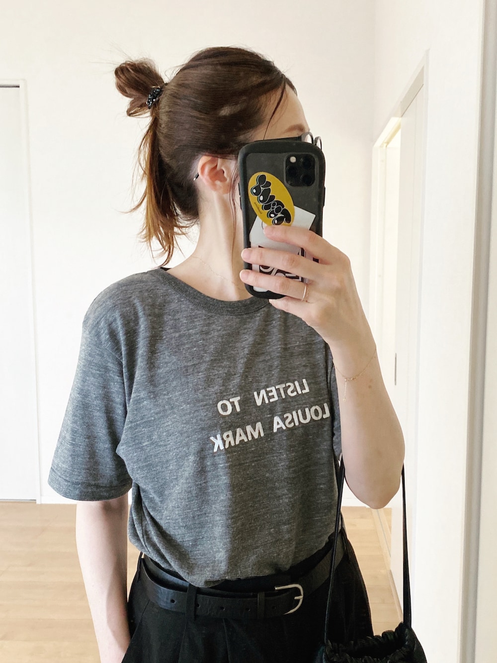 グレー系のTシャツ/カットソー、ブラック系のハンドバッグ、ブラック系のパンツを着用したレディースの夏コーディネートの4枚目の写真