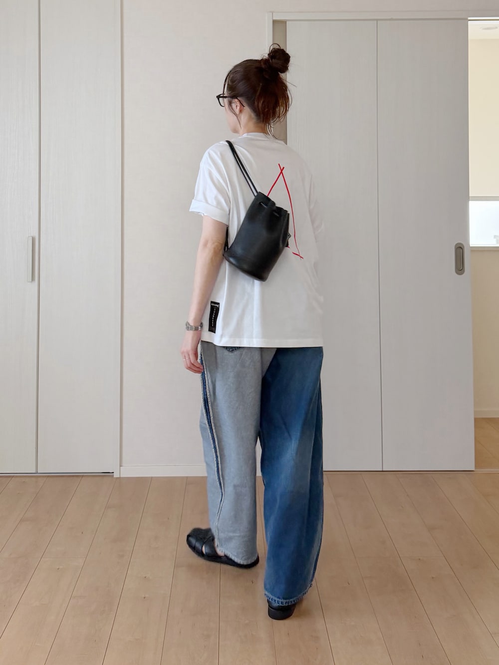 ホワイト系のTシャツ/カットソー、ブルー系のデニムパンツ、ブラック系のサンダルを着用したレディースの夏コーディネートの3枚目の写真