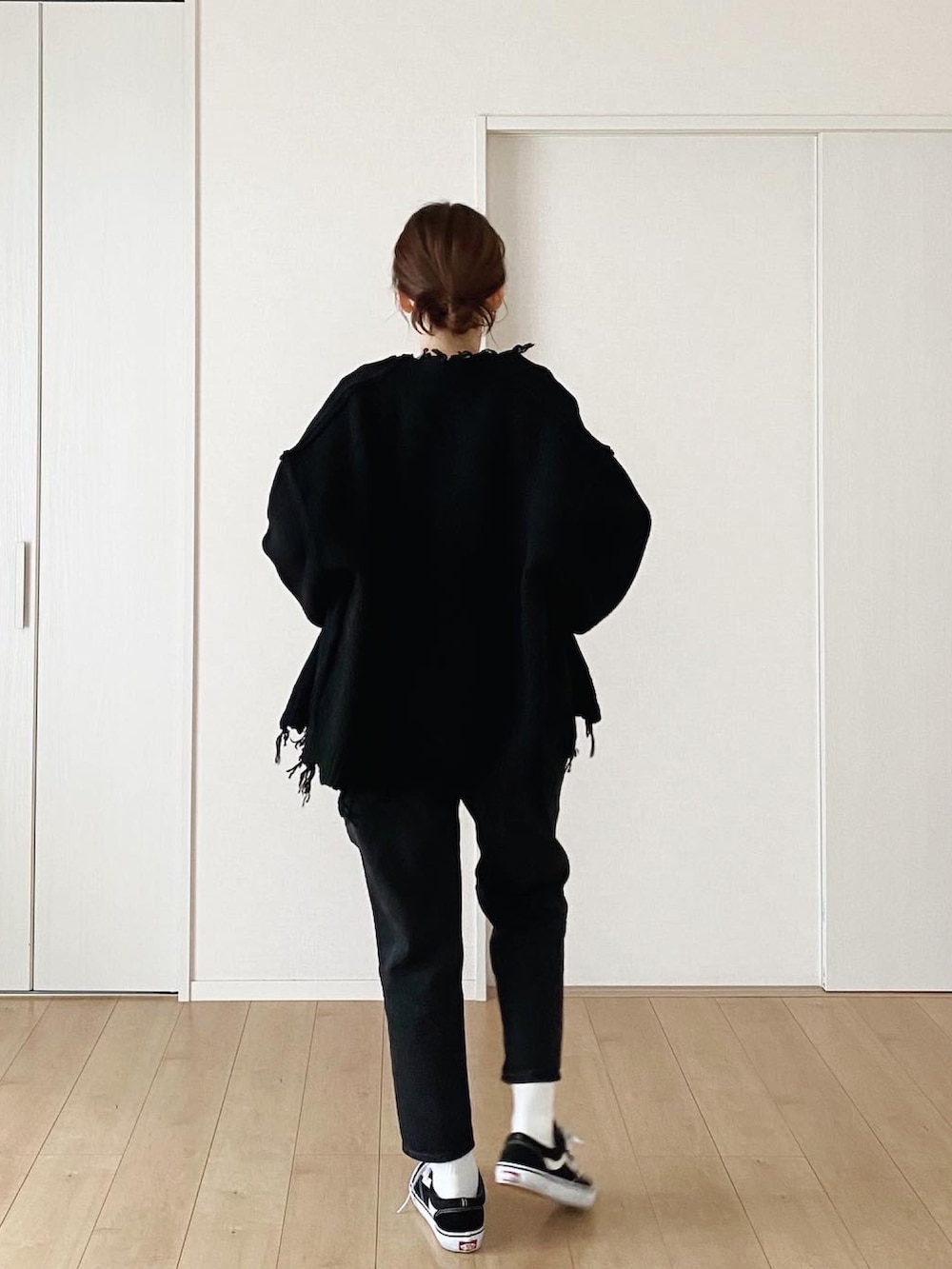 ブラック系のモッズコート、ブラック系のデニムパンツ、ブラック系のスニーカーを着用したレディースの冬コーディネートの3枚目の写真