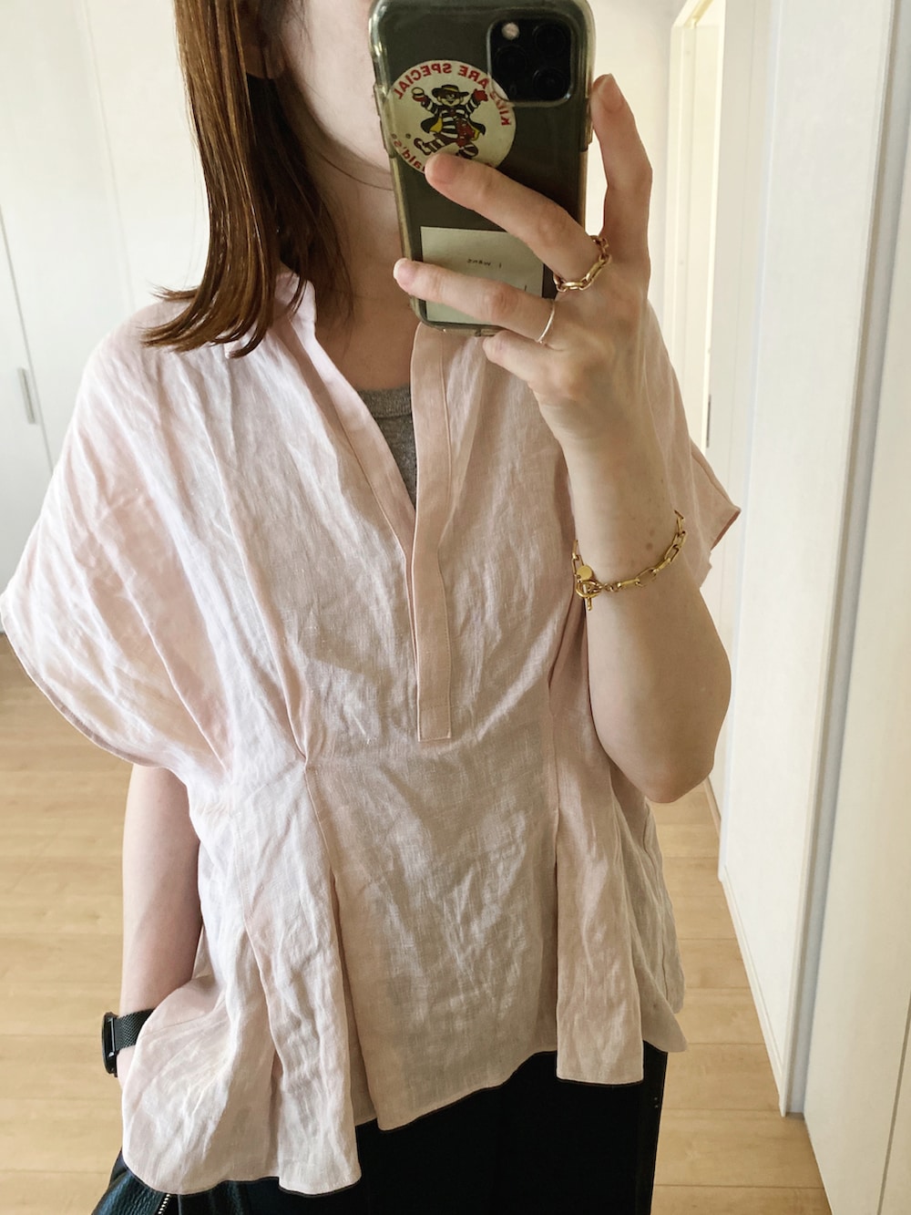 ピンク系のシャツ/ブラウス、ブラック系のハンドバッグ、ブラック系のスラックスを着用したレディースの夏コーディネートの3枚目の写真